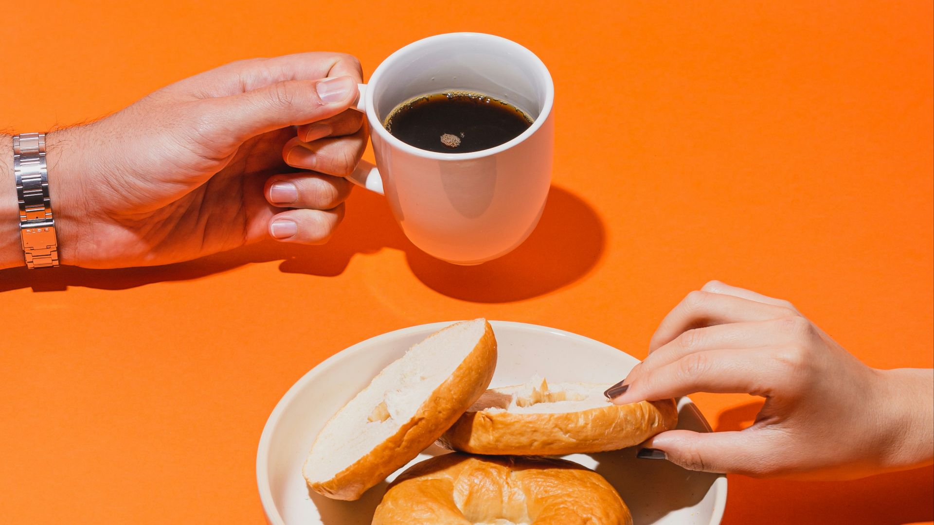 person holding white ceramic mug with brown liquid