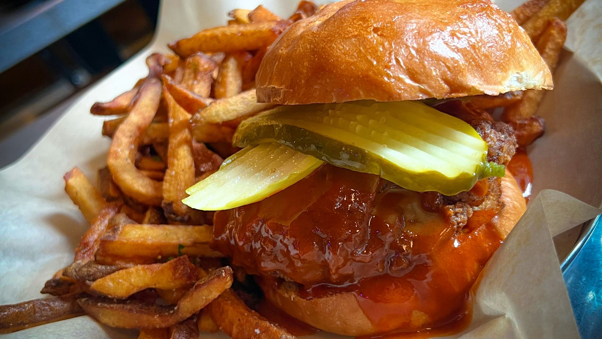 a hamburger with pickles and onions on a roll