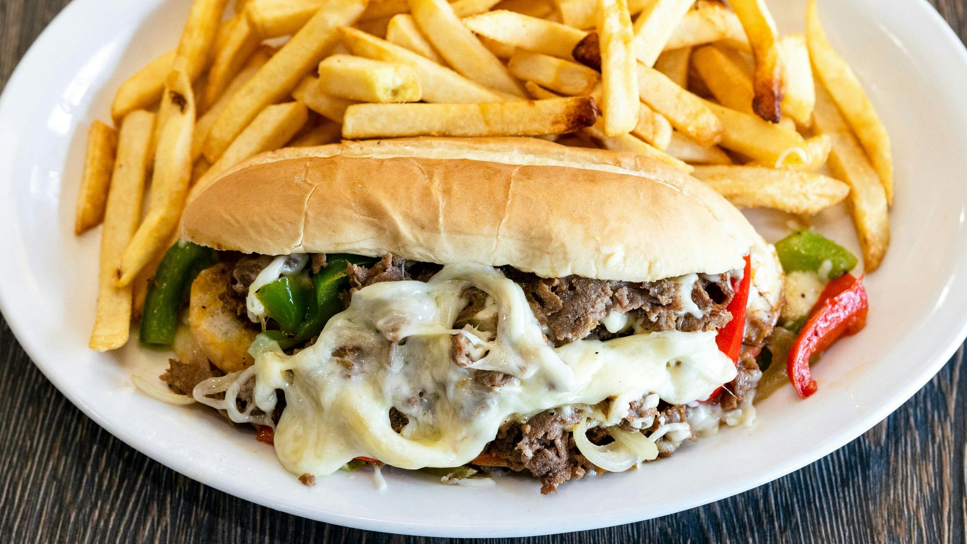 A white plate topped with a sandwich and fries