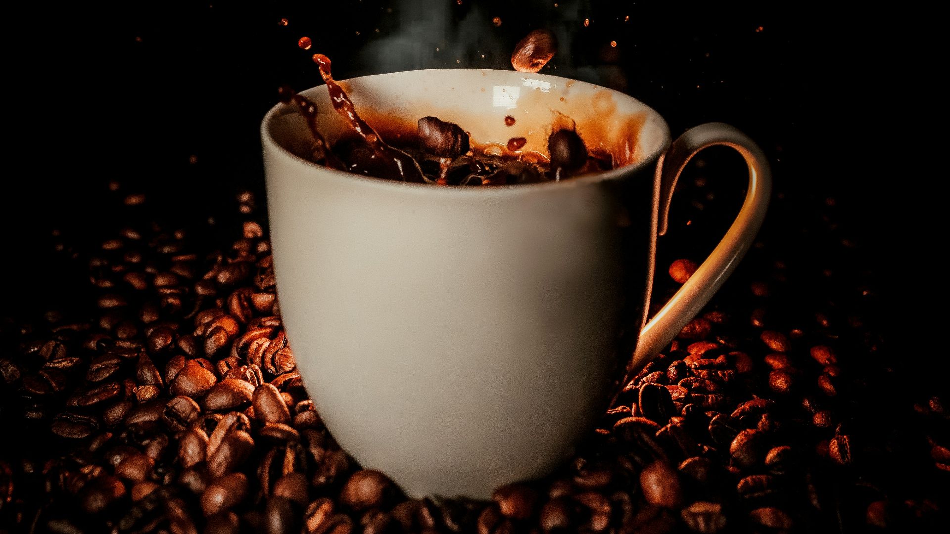 white ceramic teacup with coffee beans