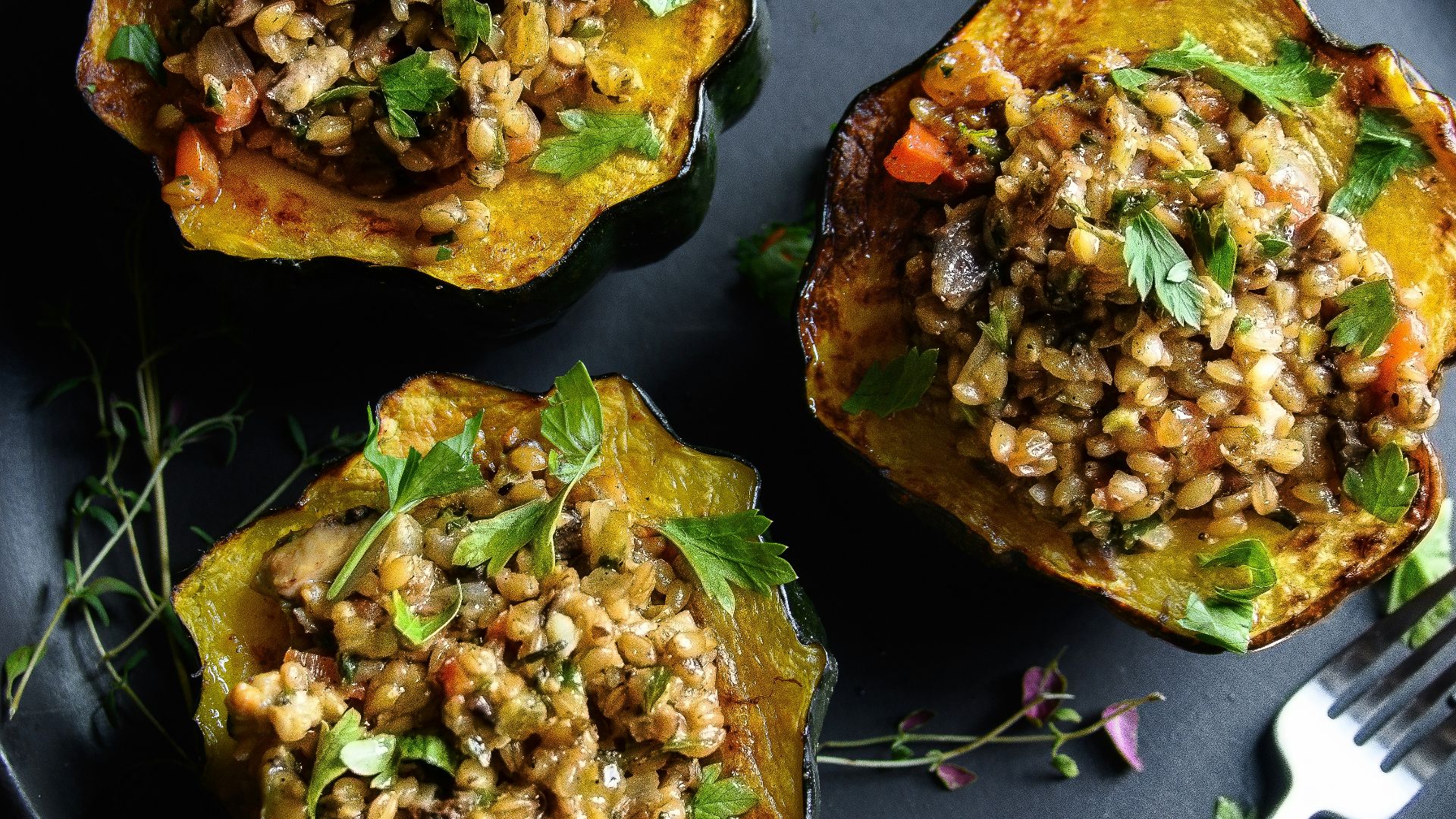 a black plate topped with three stuffed acorns
