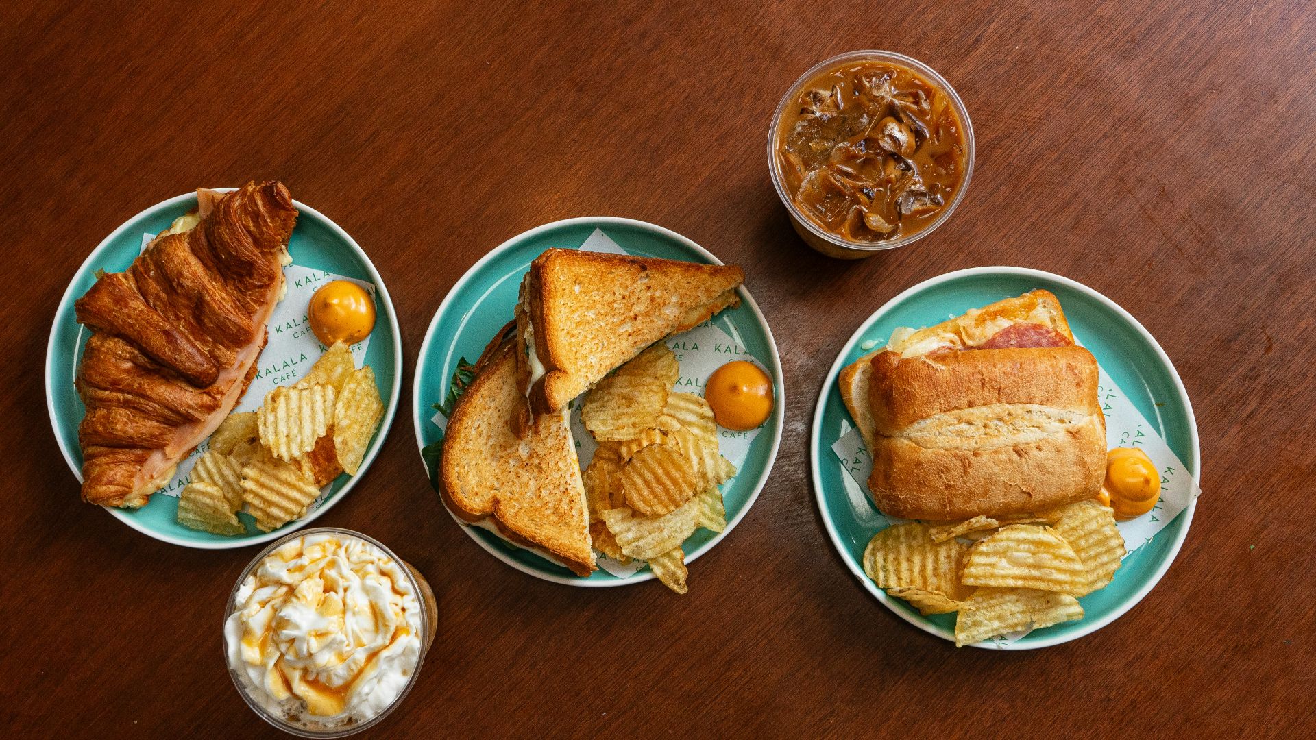 A wooden table topped with three plates of food