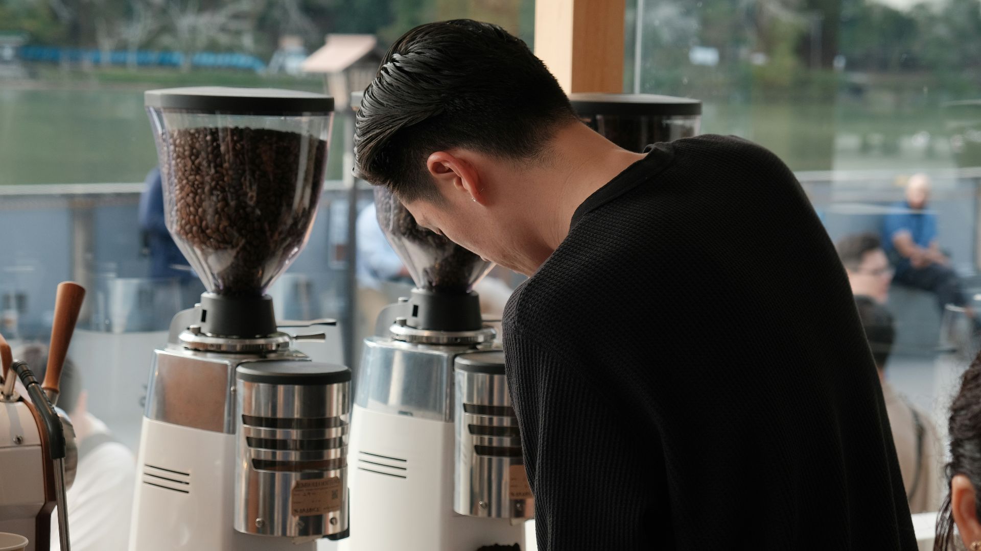 Barista preparing coffee with grinders in-store grinders