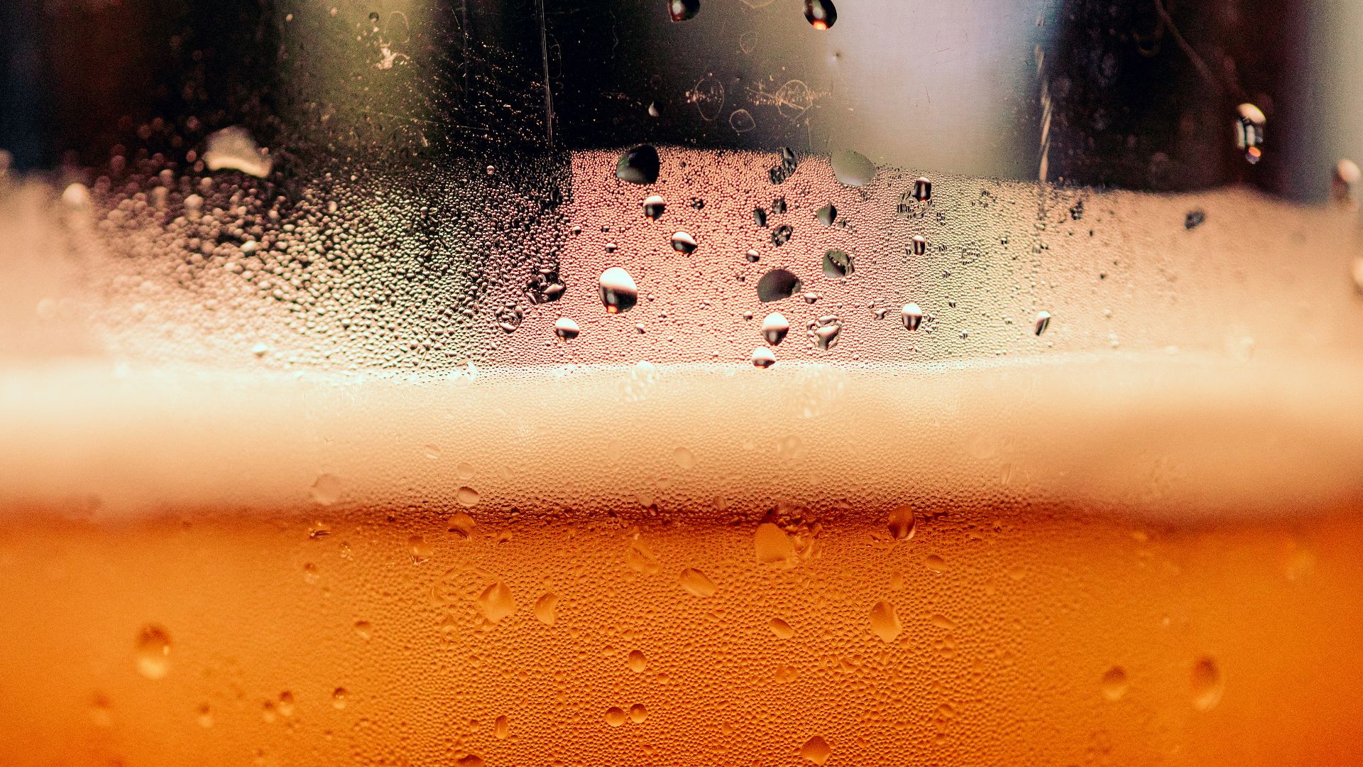 a close up of a glass of beer with drops of water