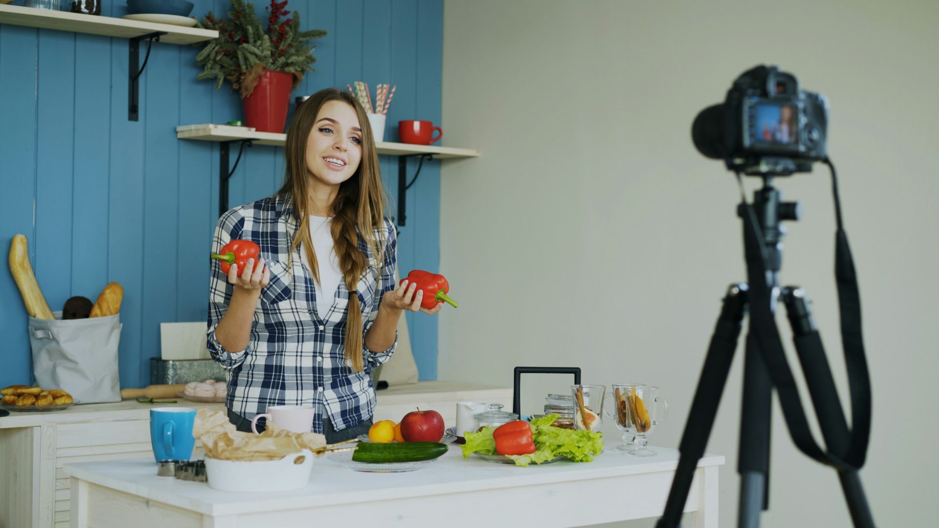 Woman filming cooking tutorial with fresh vegetables