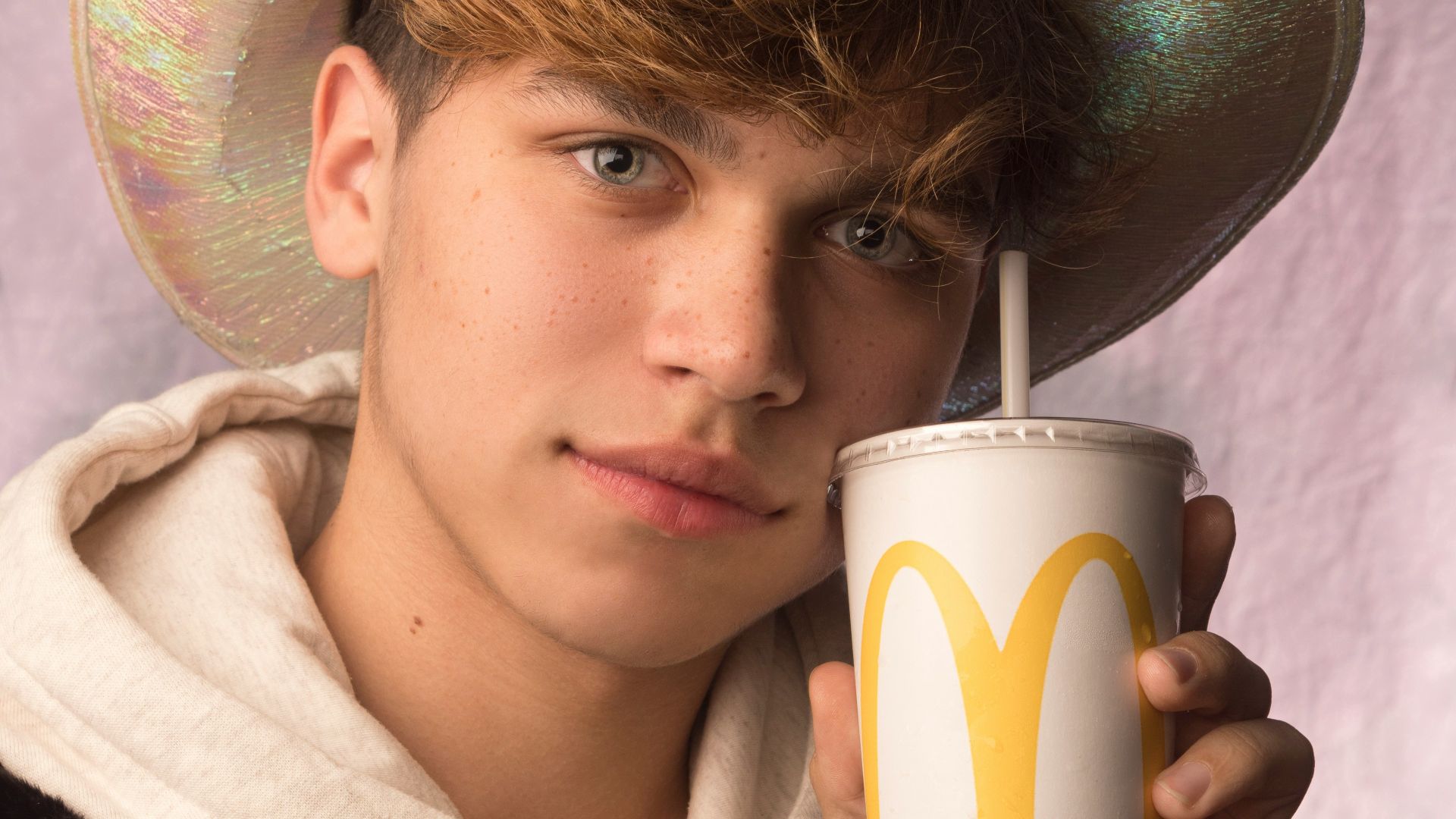 woman in white and black coat holding white and green disposable cup