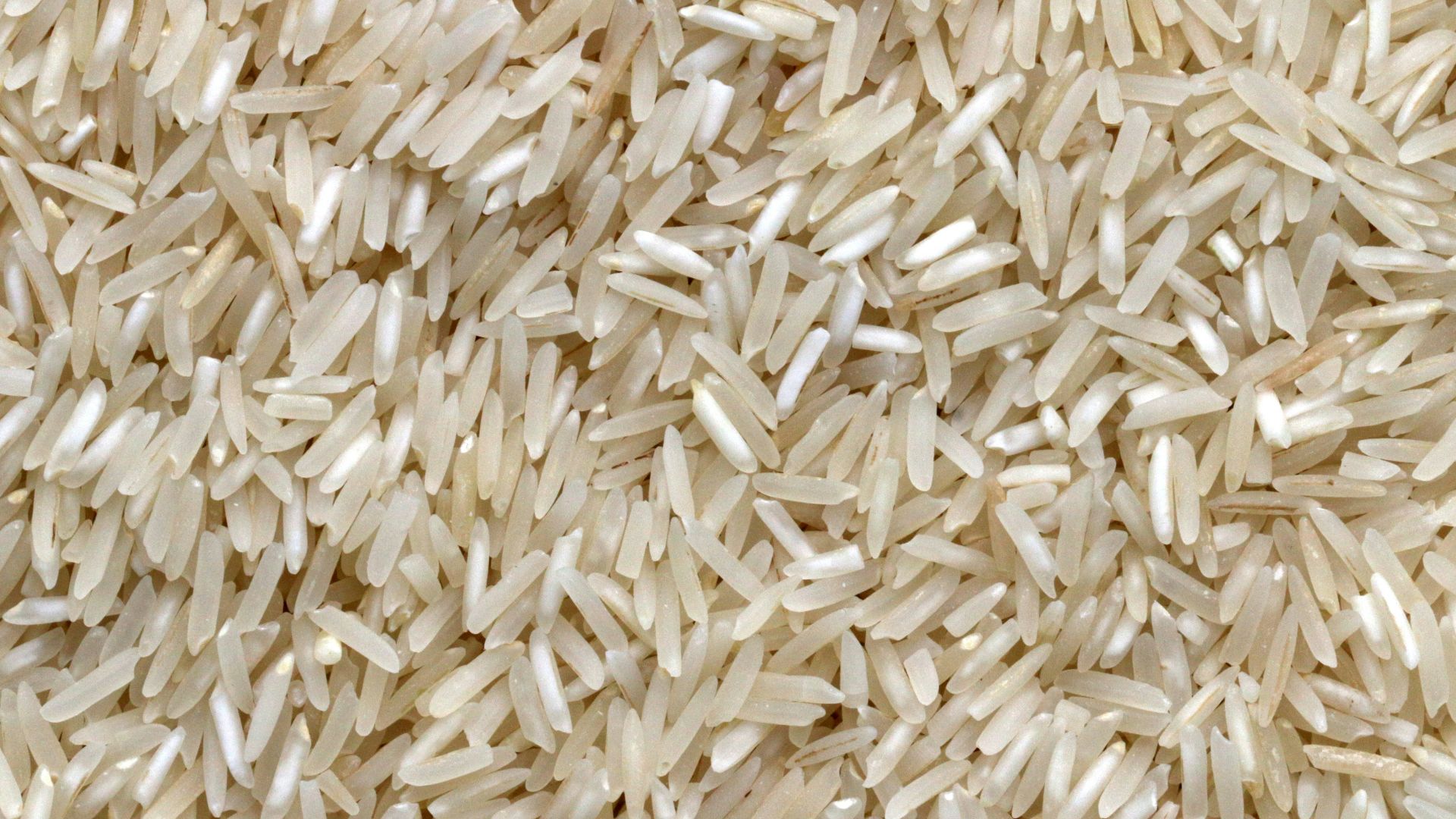 white rice grains on brown wooden table