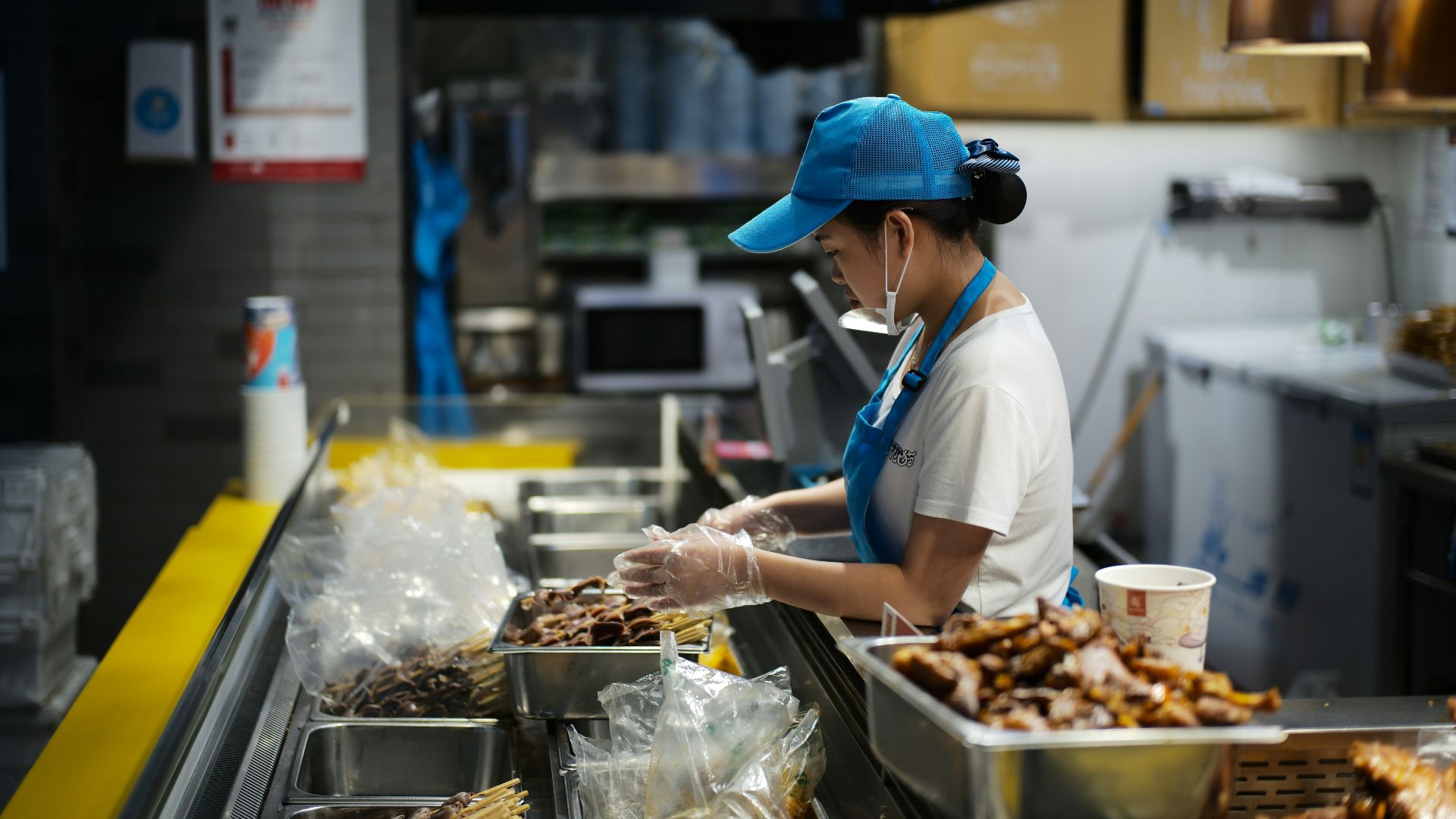 A person working behind a food counter.