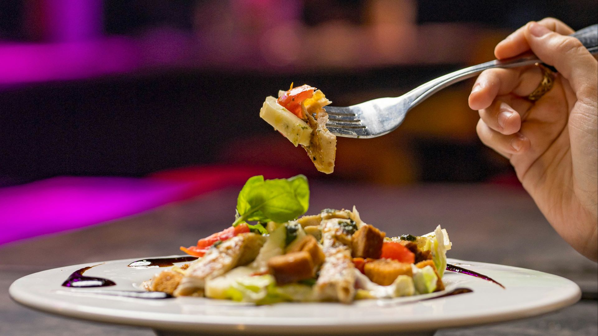 A person eating a plate of food with a fork