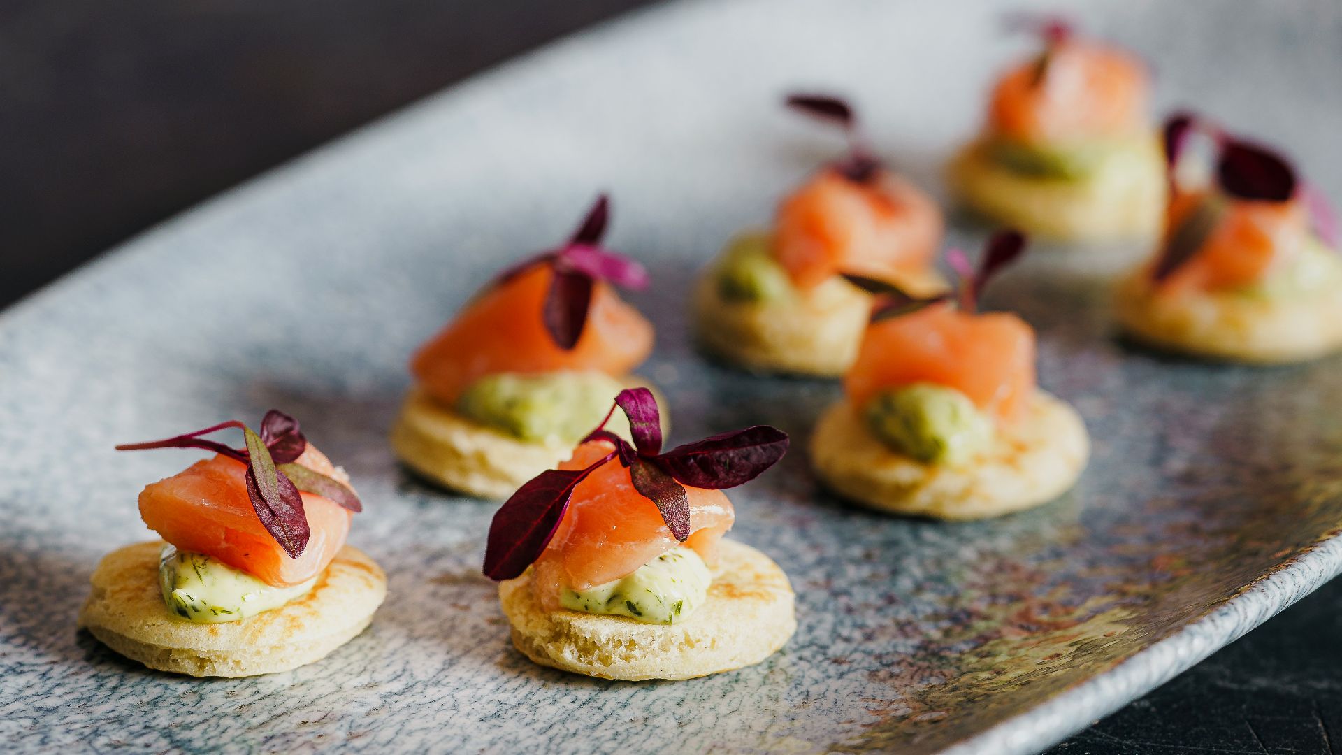 small appetizers are arranged on a silver plate