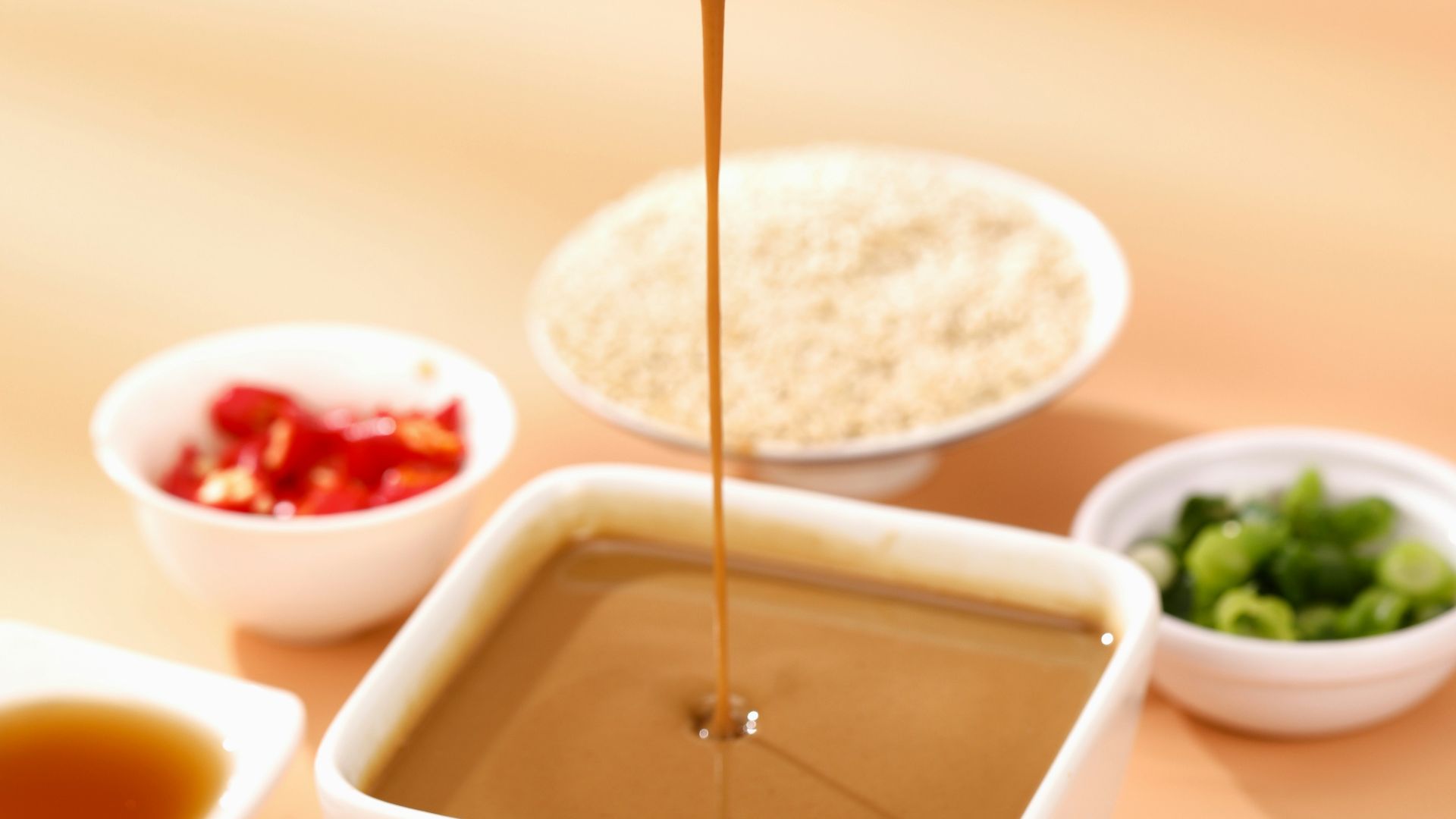 a person dipping sauce into a bowl of food