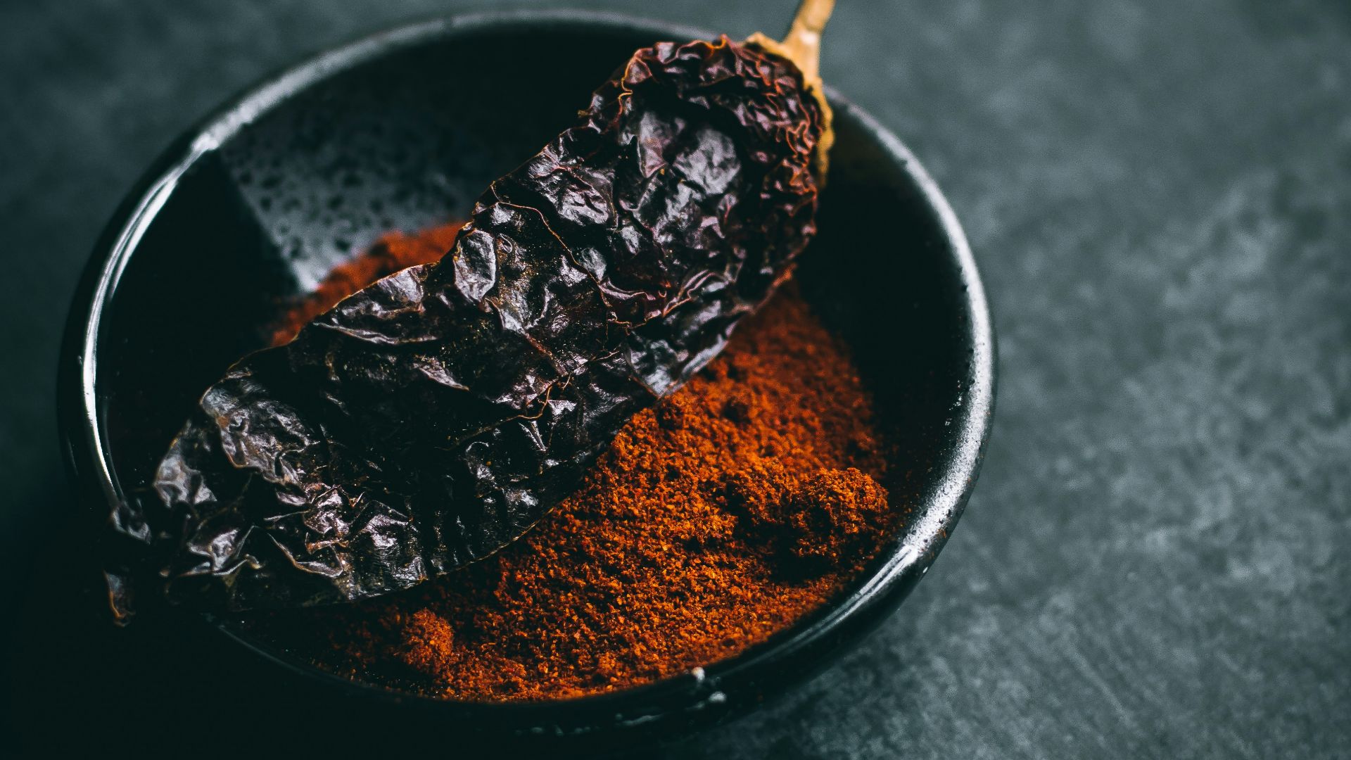 dried chili on black ceramic bowl