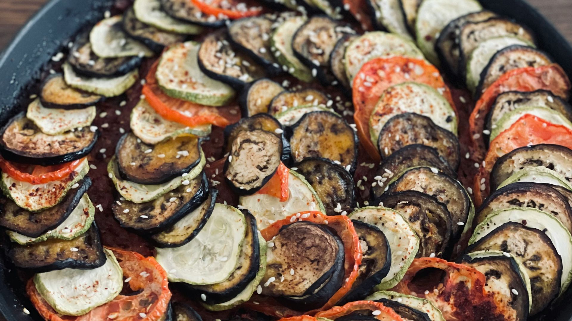 a pan filled with sliced up vegetables on top of a wooden table
