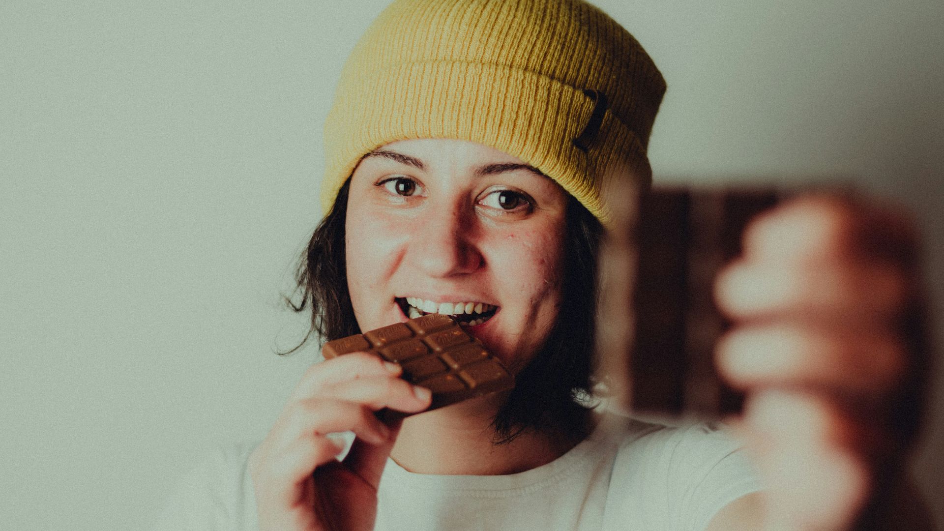 woman in white crew neck t-shirt wearing yellow knit cap