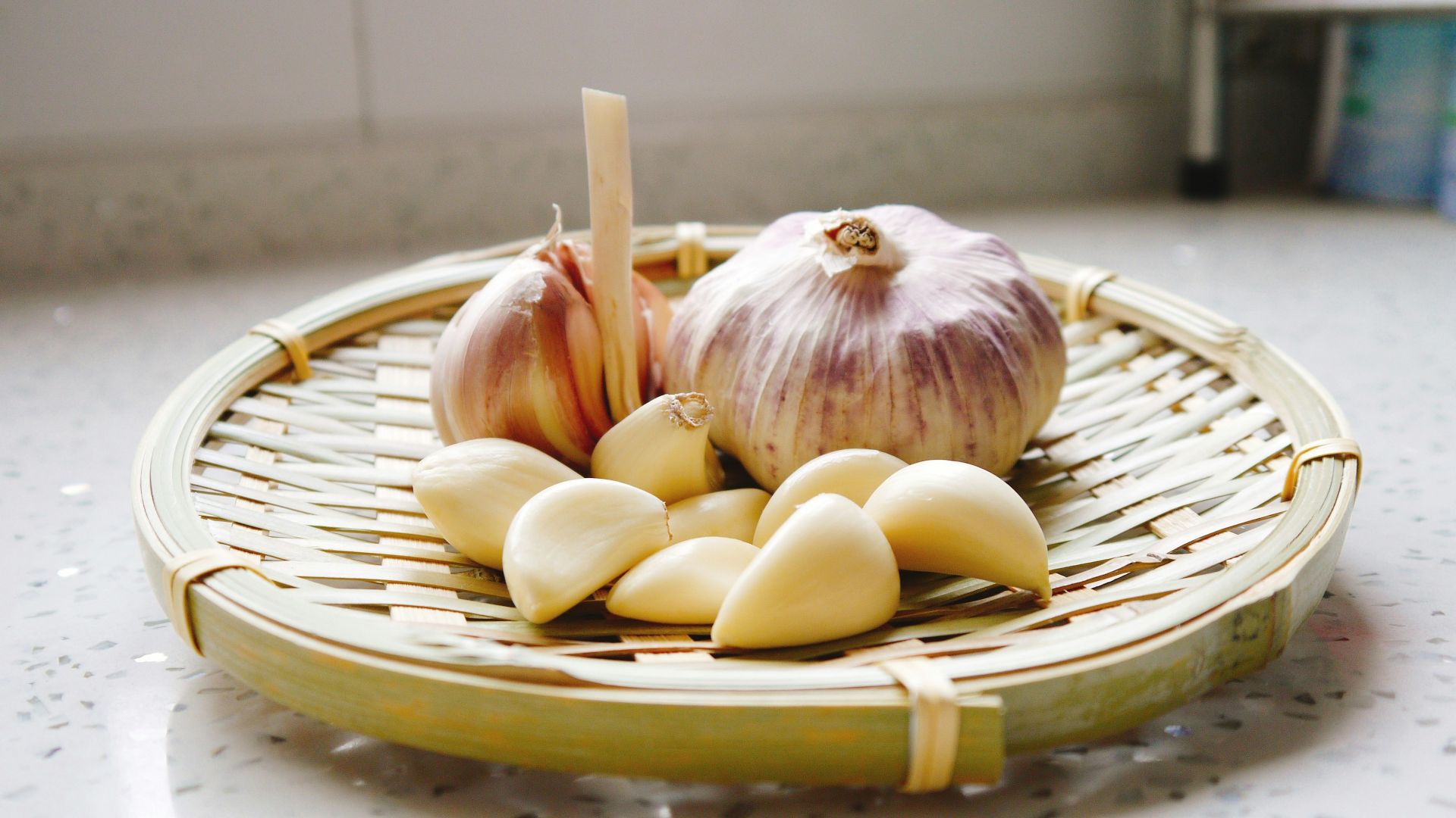 a basket of garlic and garlic bulbs on a counter