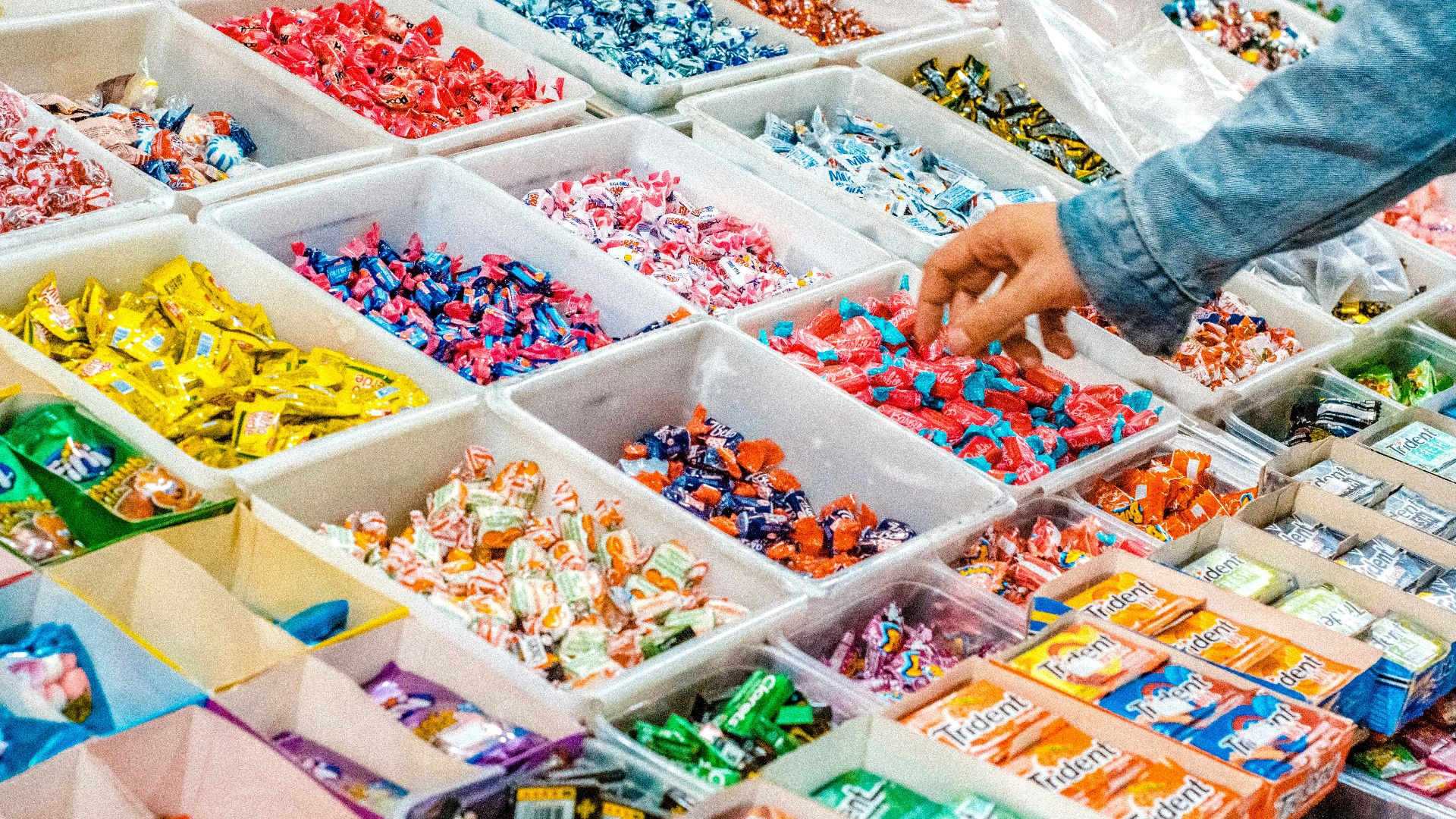 person holding a candy pack on white plastic box