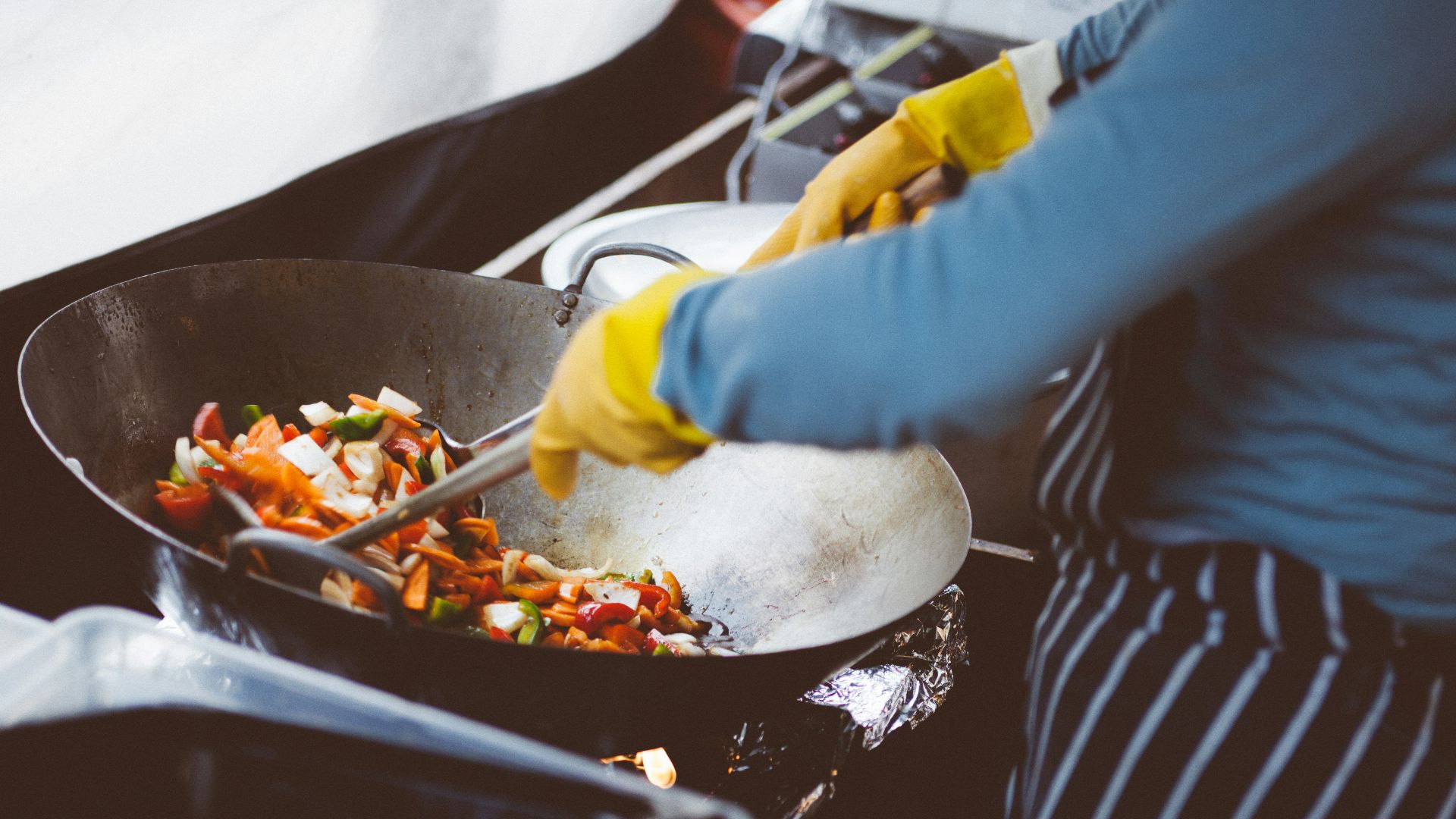 person mixing vegetable in wok