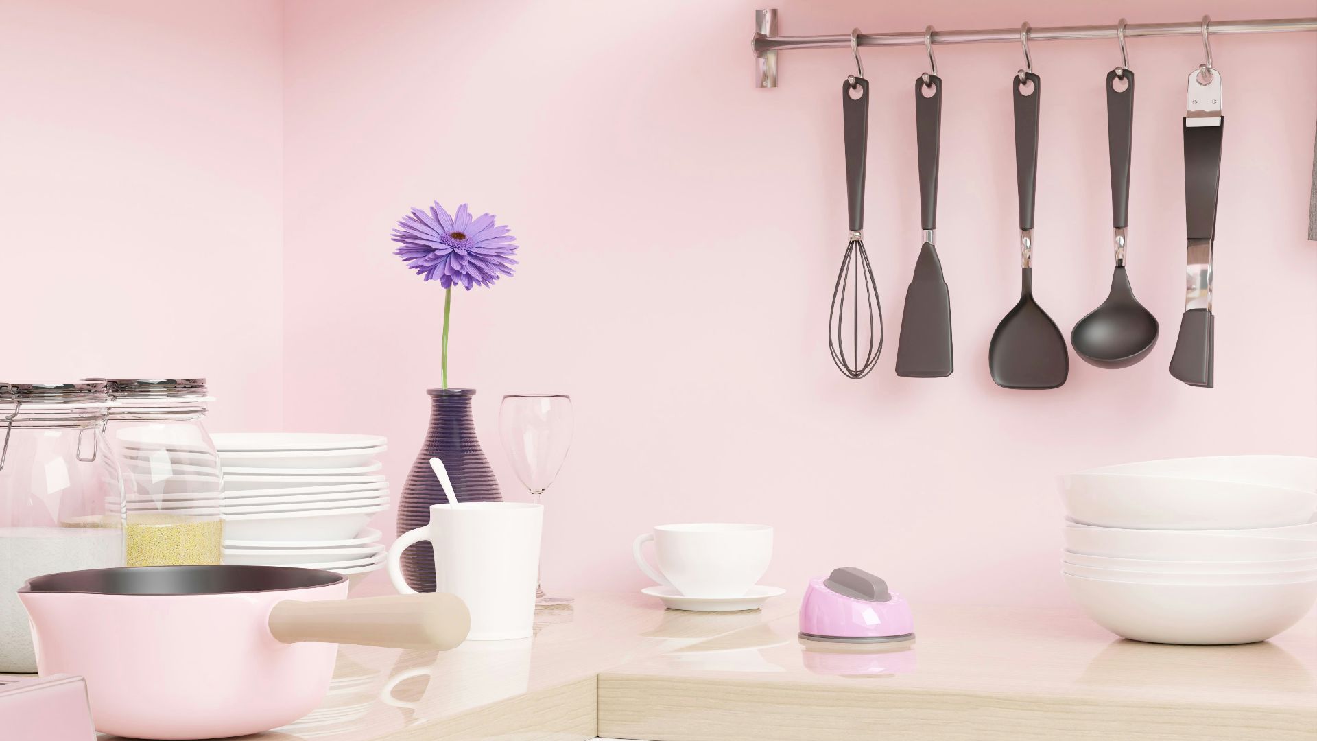 a pink kitchen with utensils hanging on the wall
