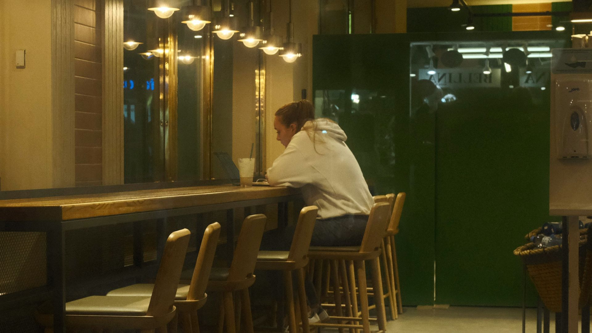 Person sitting alone at a cafe counter