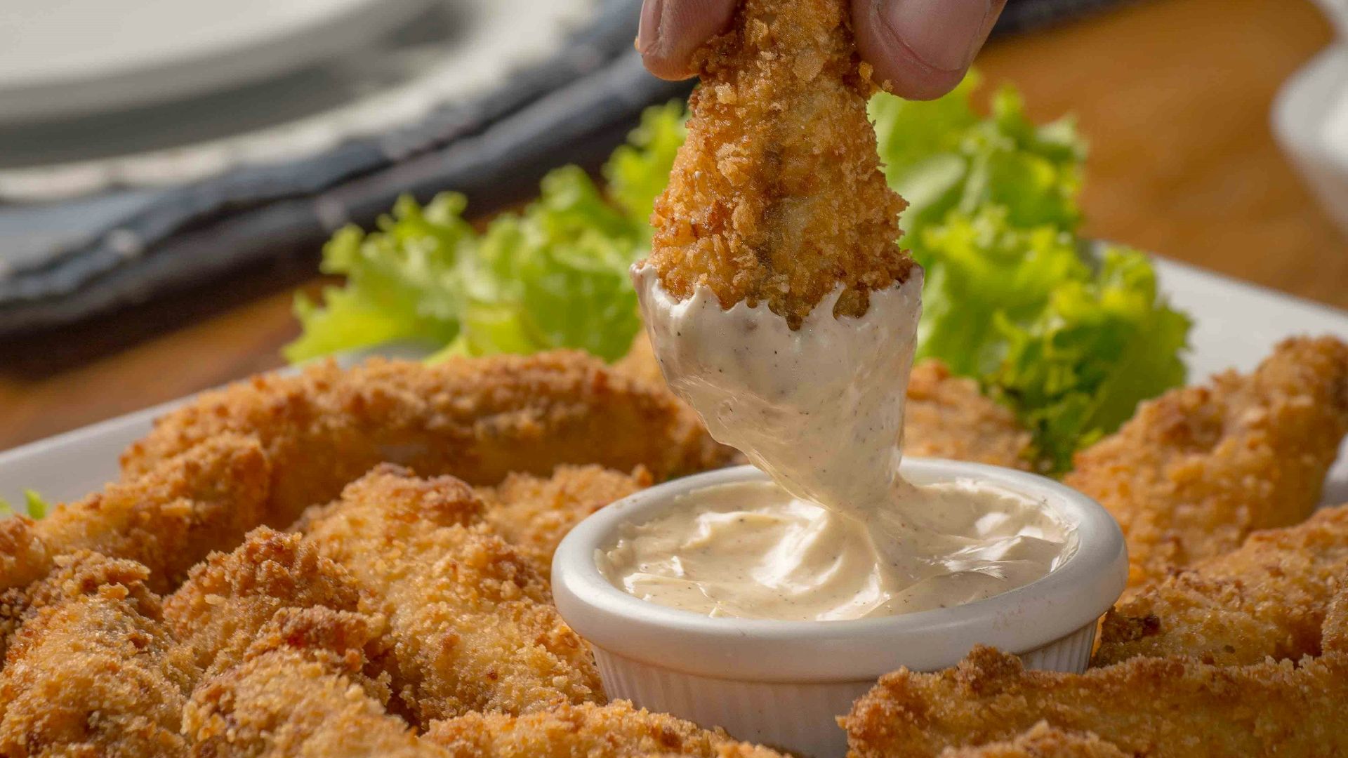 person dipping fried cuisine on dip