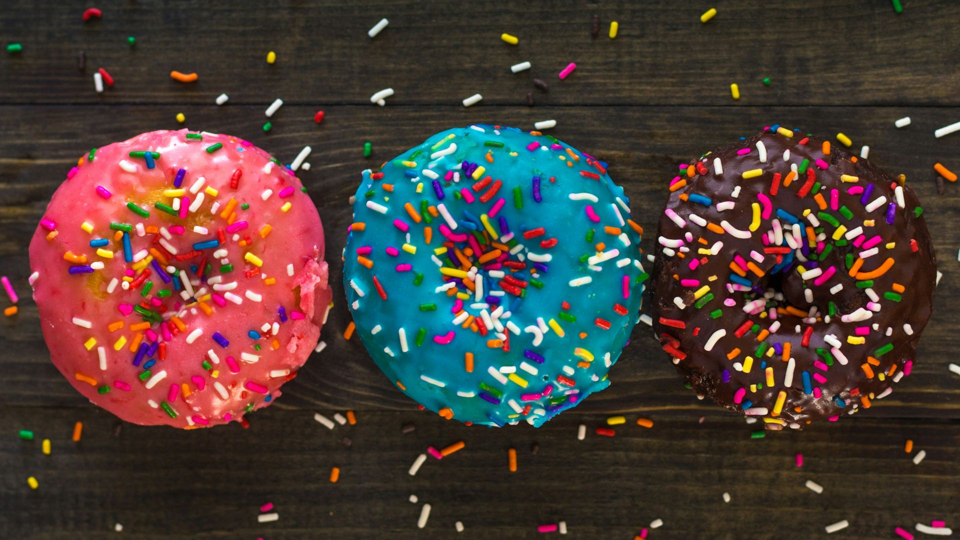 three donuts with sprinkle toppings