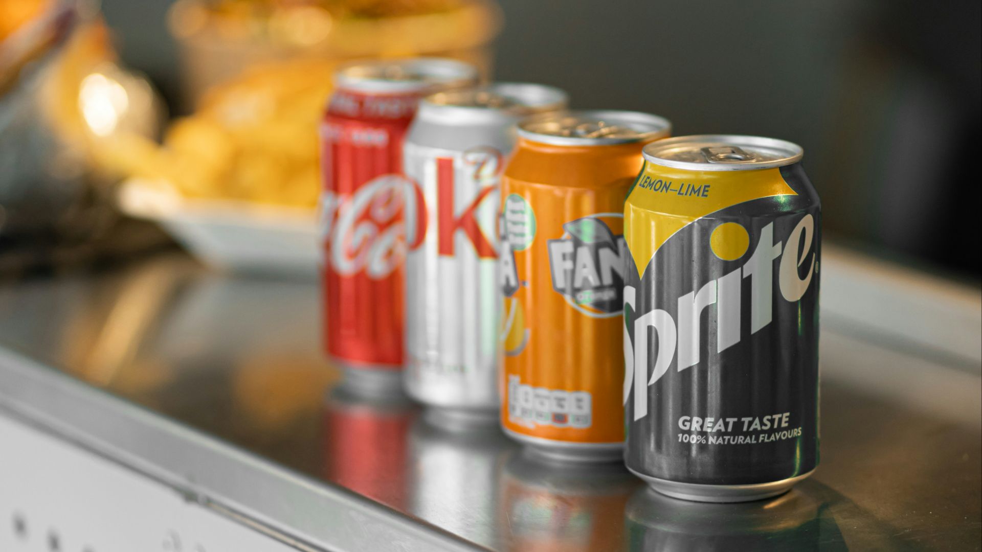 two coca cola cans on stainless steel table