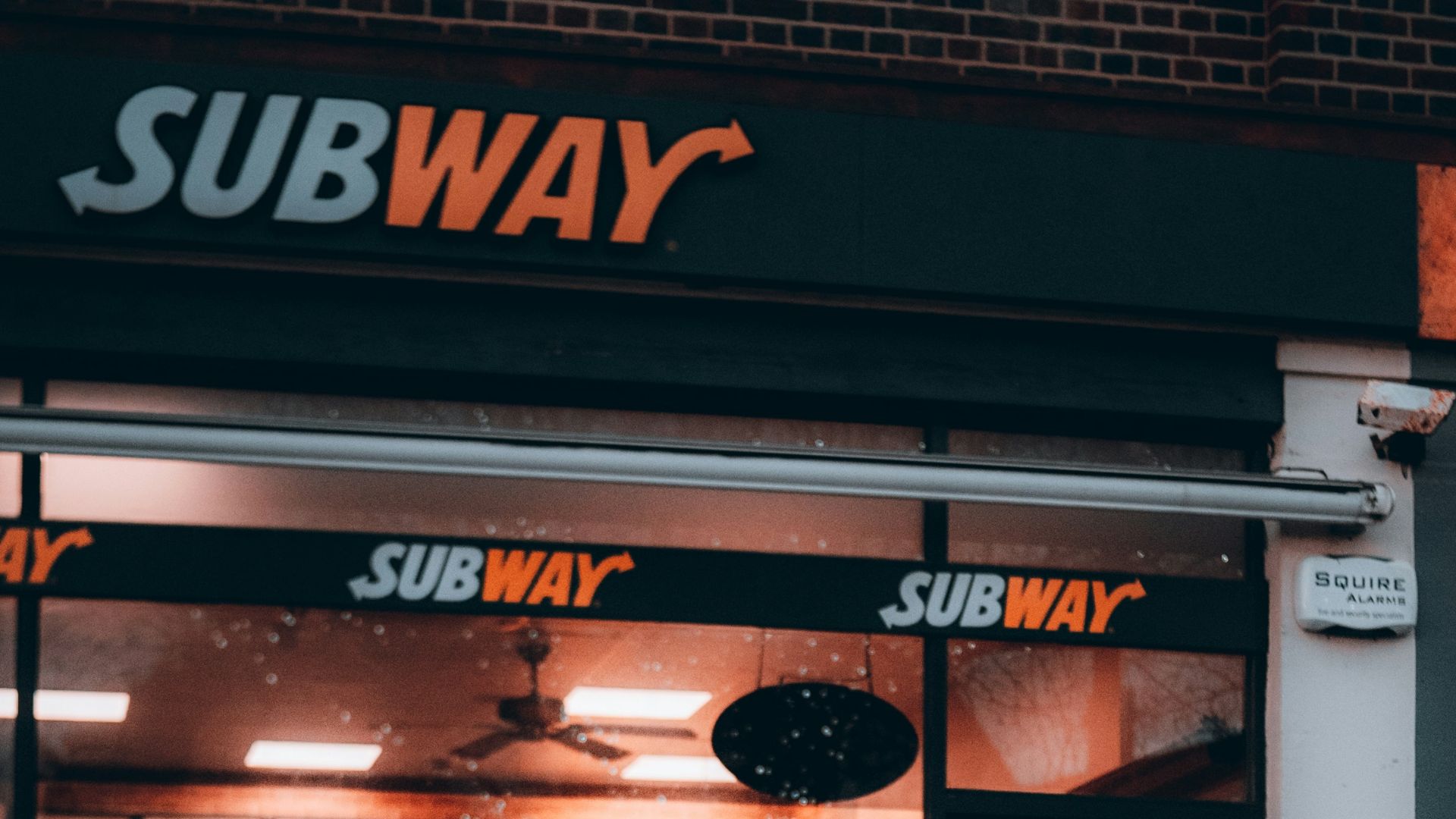man in green jacket sitting on red and black motor scooter
