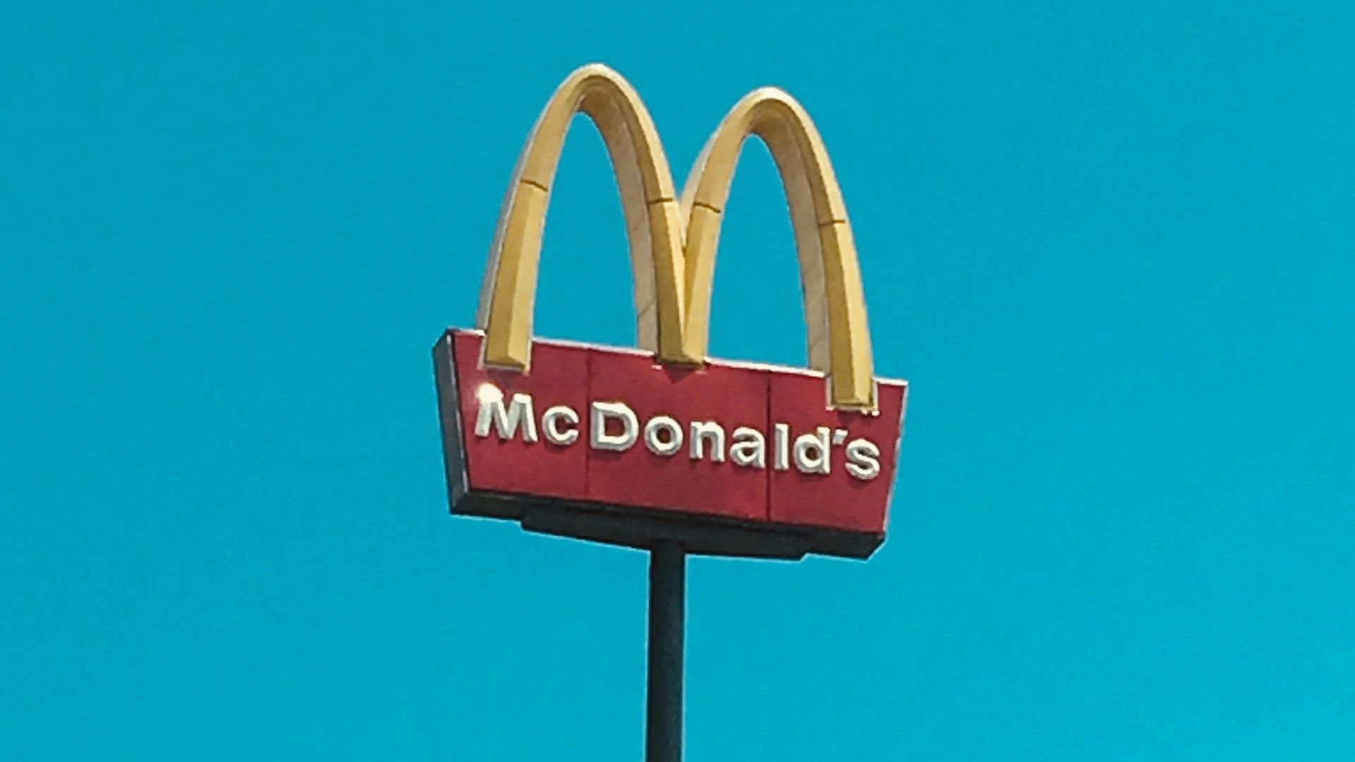 a mcdonald's restaurant sign in front of a blue sky