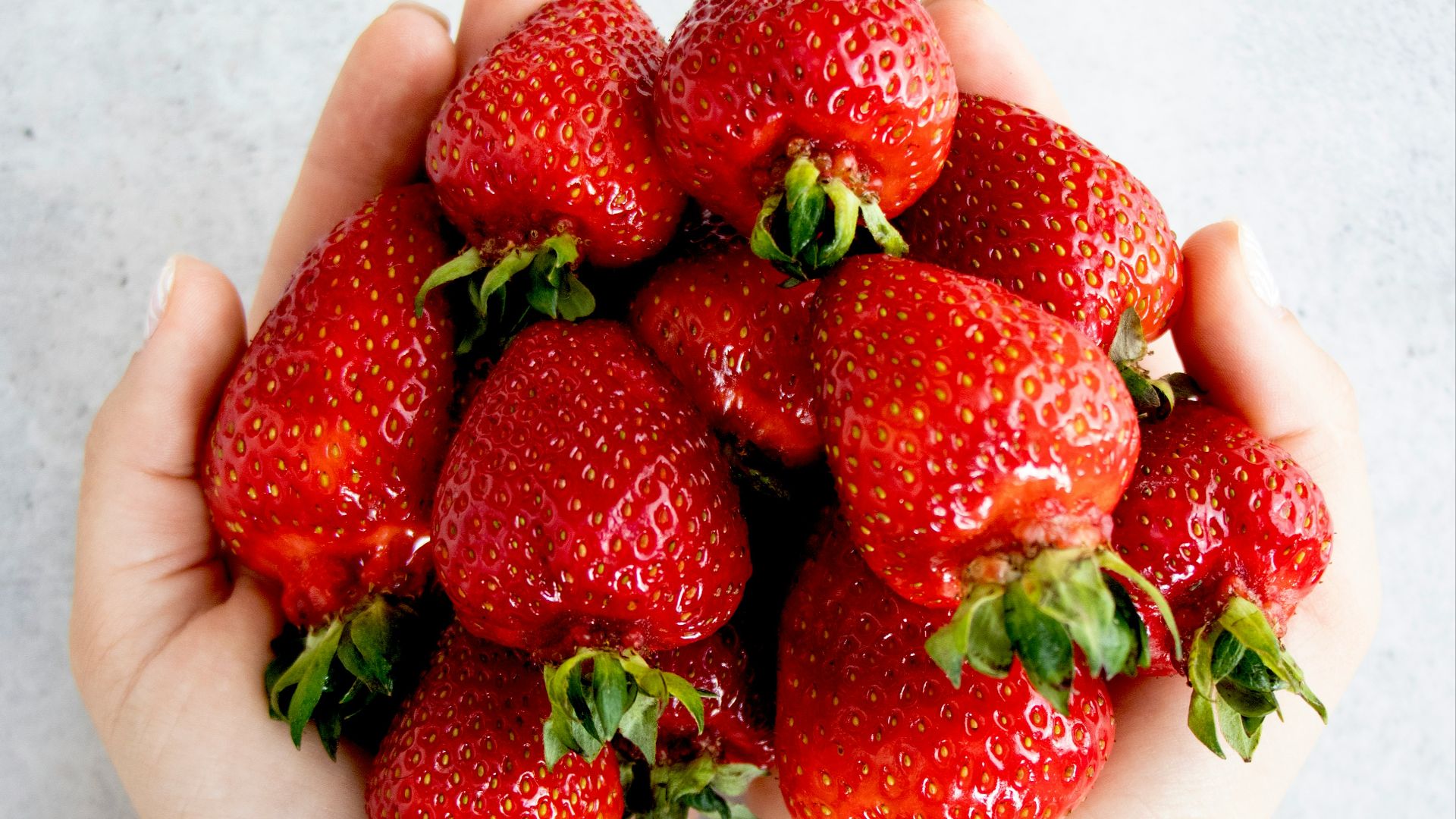 strawberries on persons hand
