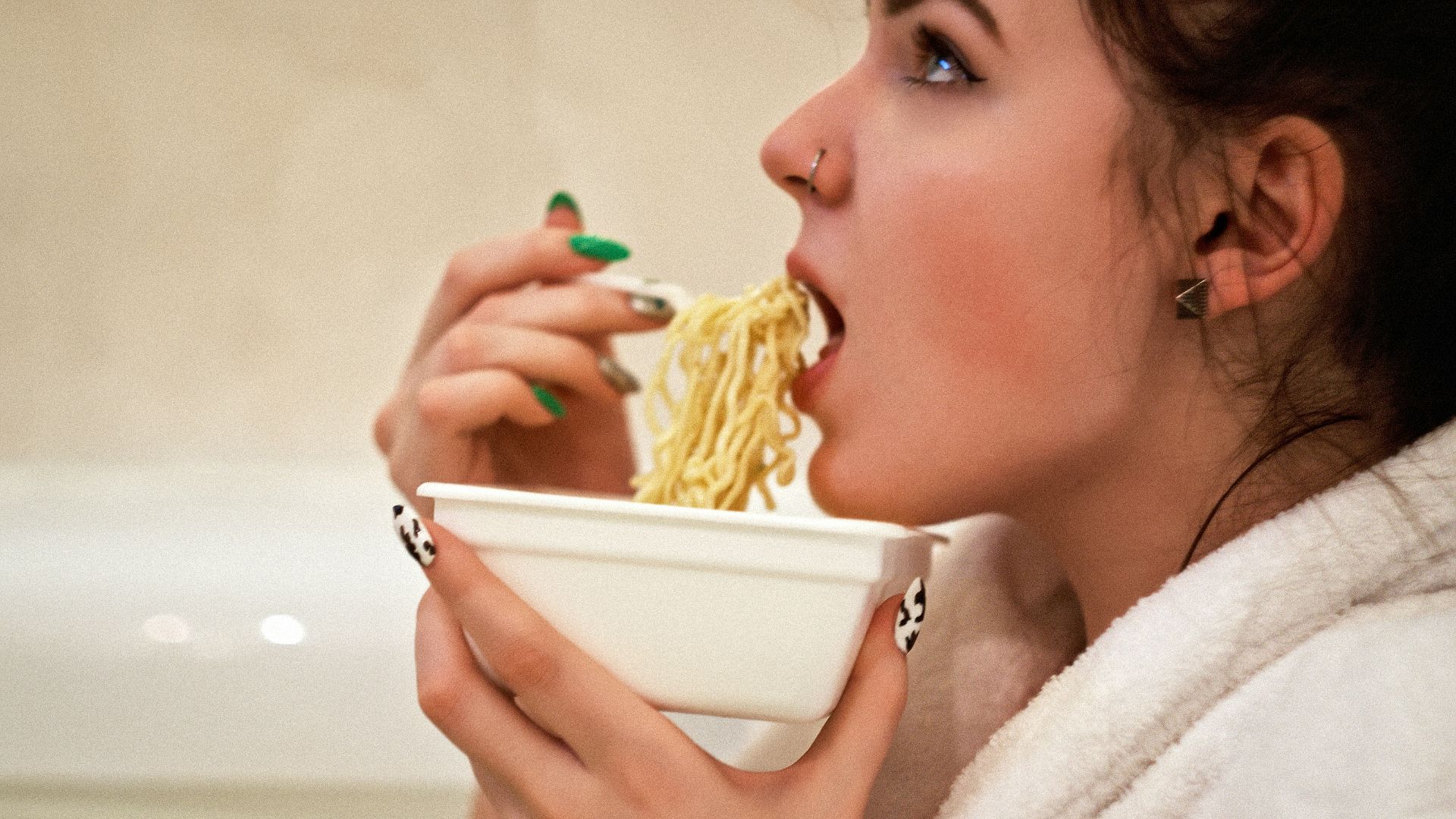 woman holding white ceramic bowl with yellow pasta