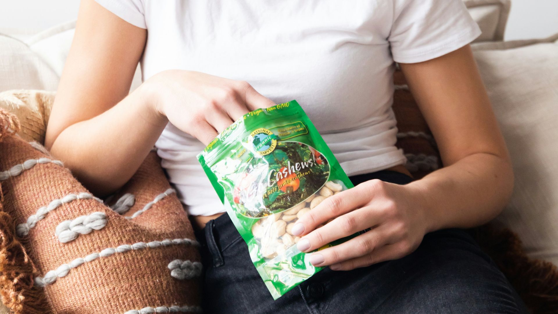 woman in white crew neck t-shirt holding green plastic pack