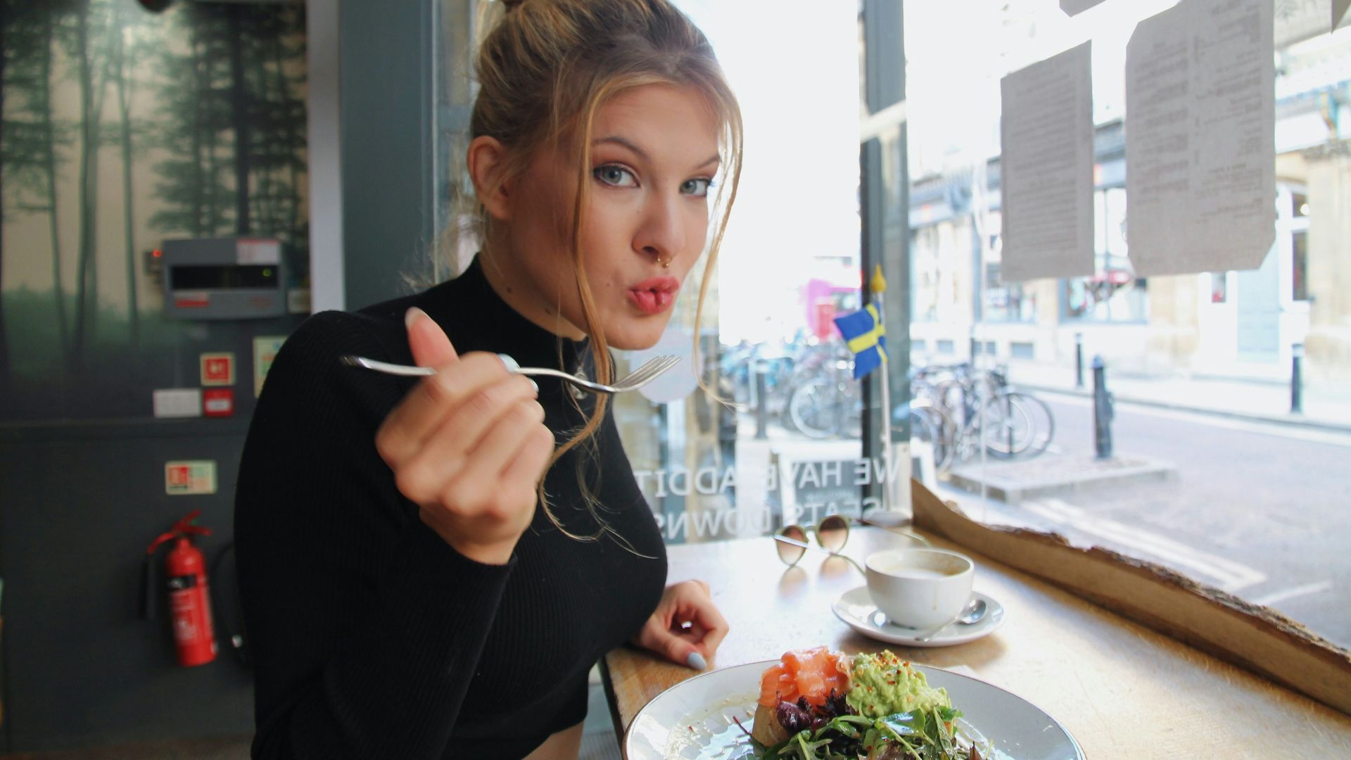 woman in black long sleeve shirt eating