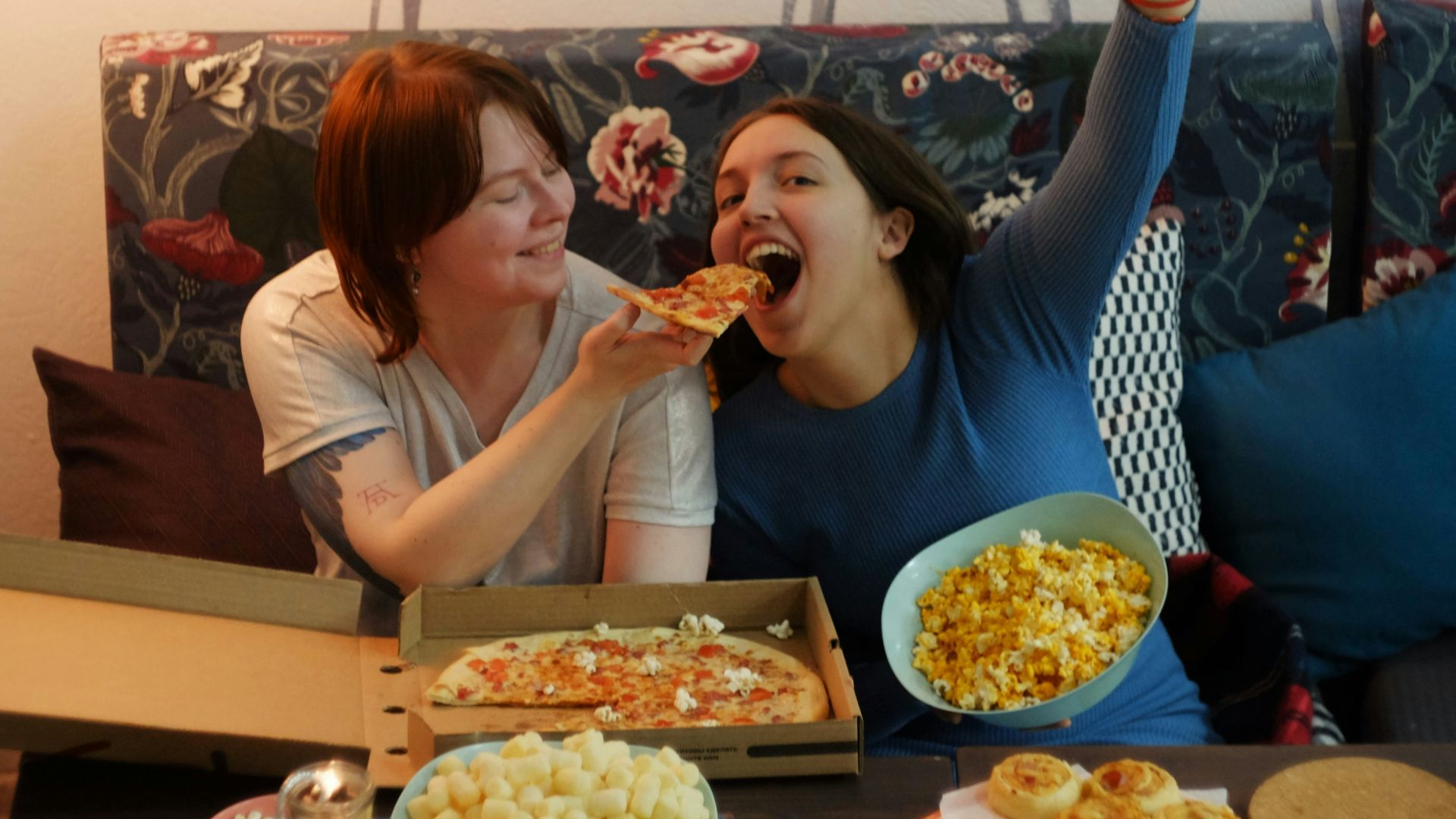 woman in white shirt eating pizza
