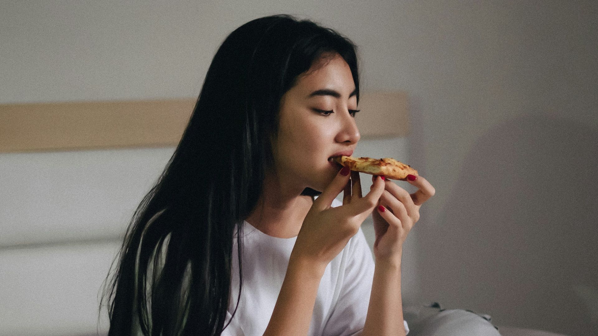 sitting woman in bed eating pastry