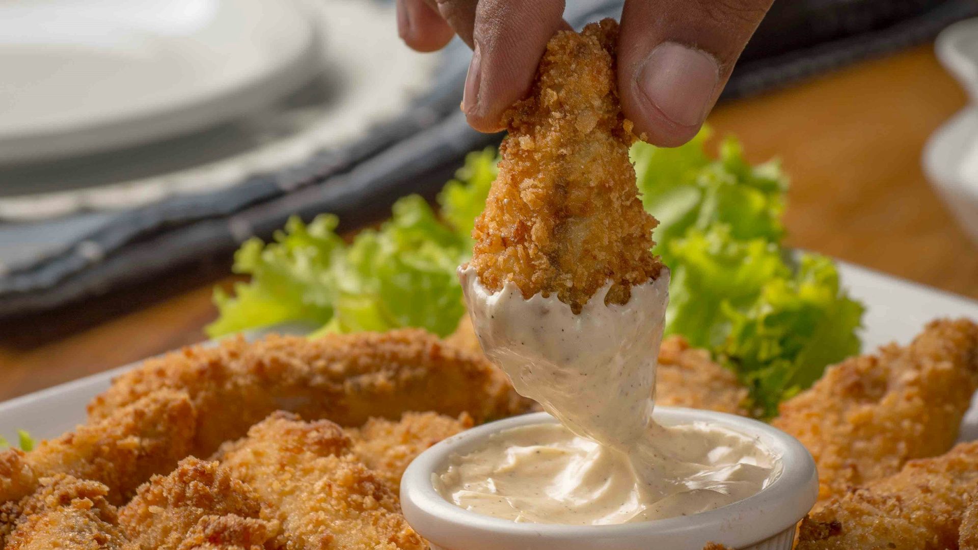 person dipping fried cuisine on dip