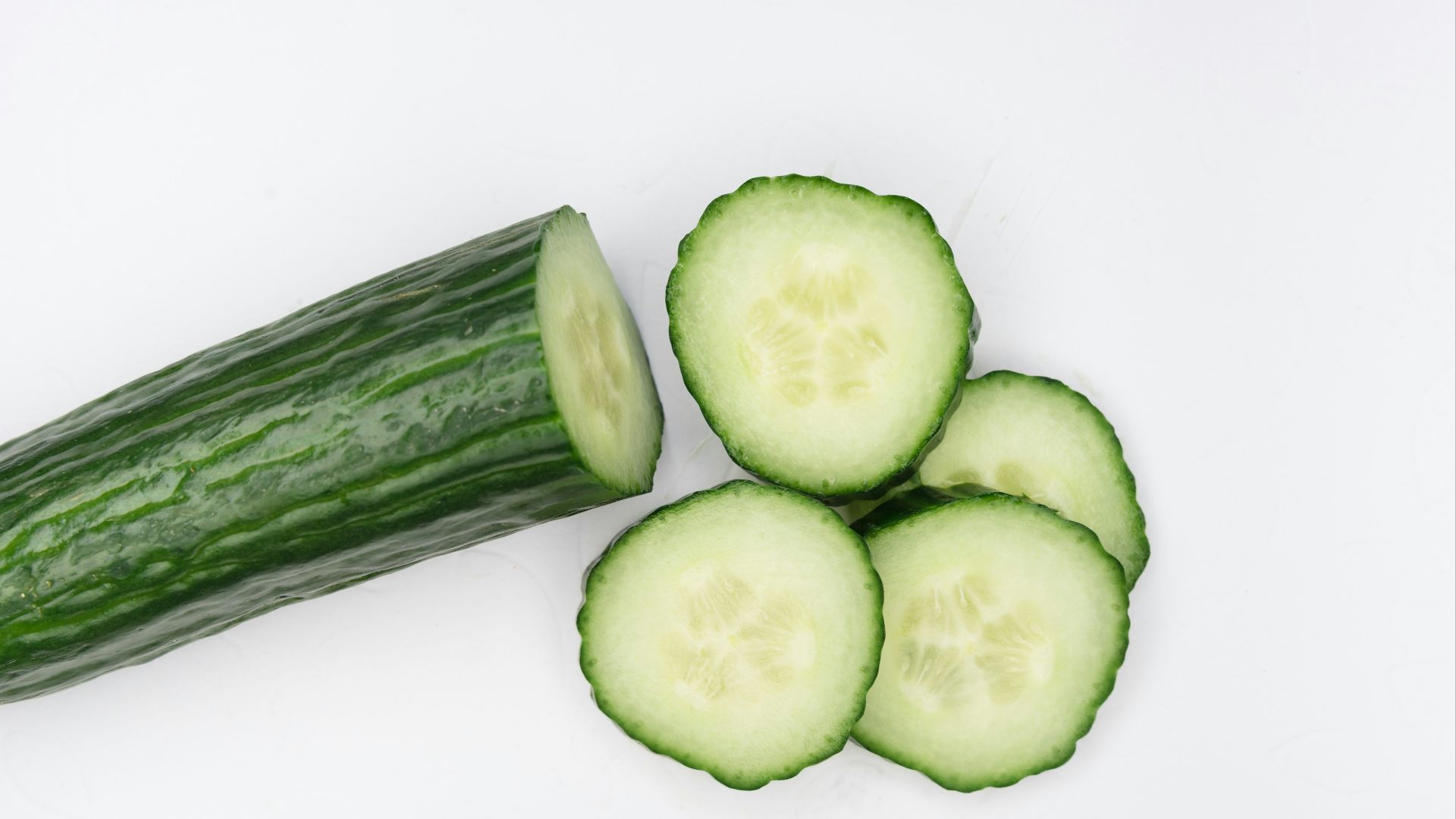 sliced cucumber on white surface