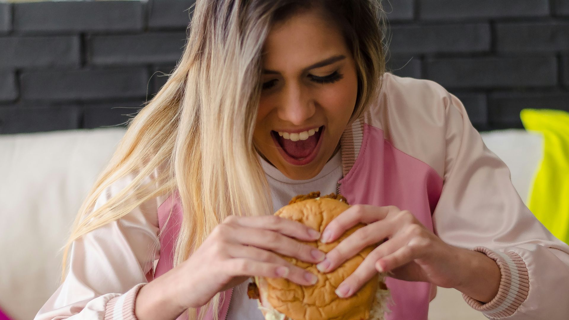 girl in pink long sleeve shirt eating bread