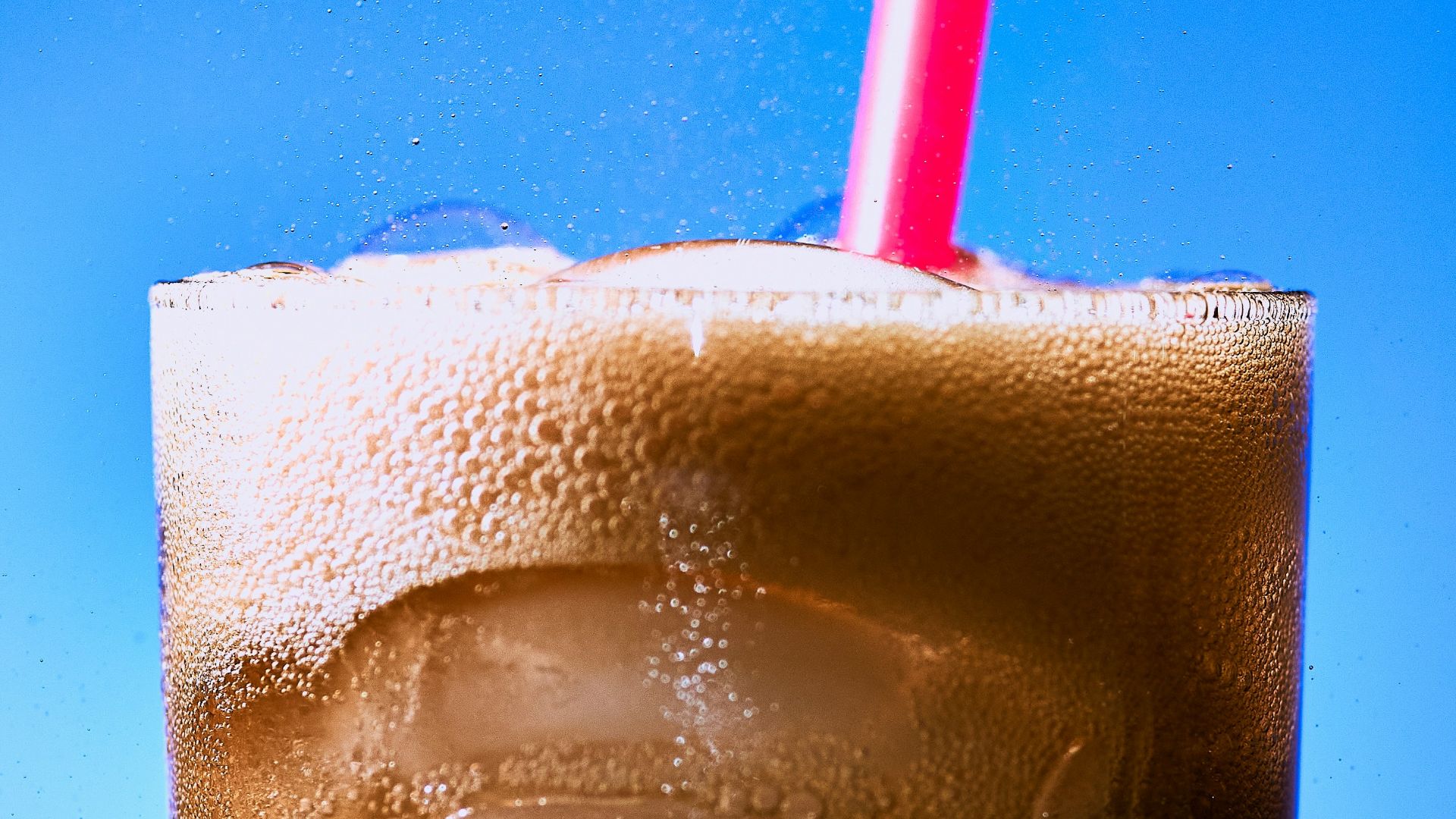 clear drinking glass with ice and red straw