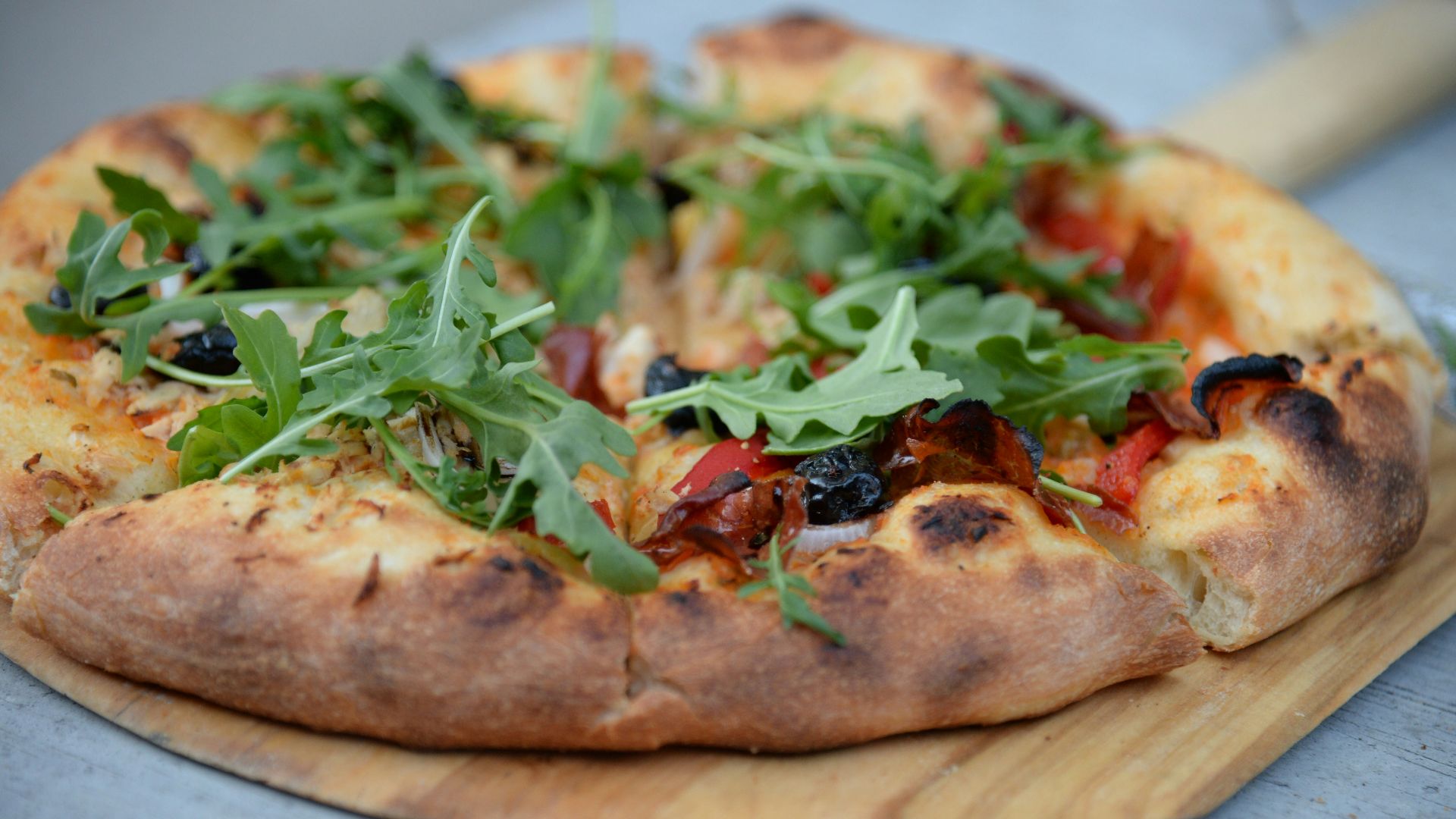 pepperoni pizza with green leafed toppings