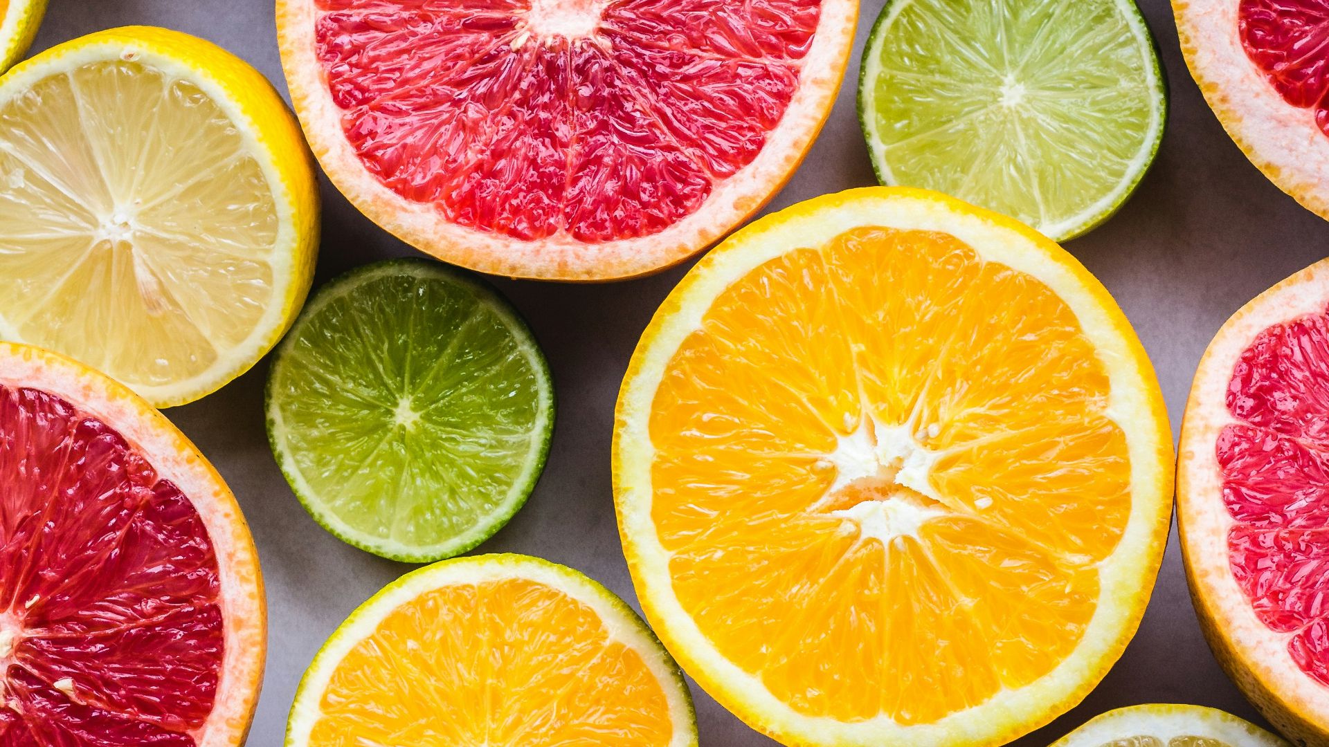 flat lay photography of sliced pomegranate, lime, and lemon