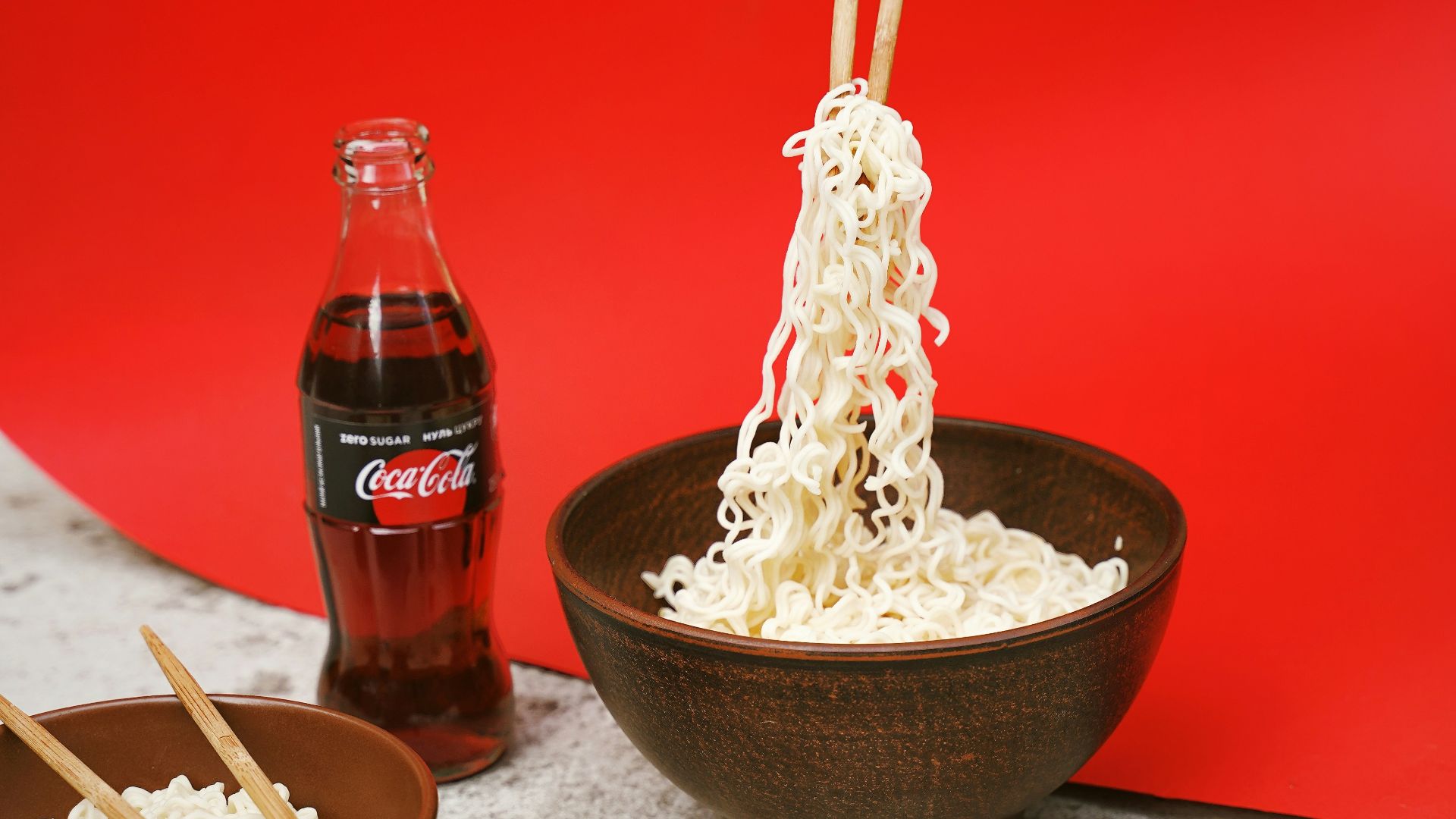 bowl of noodle near soda bottle