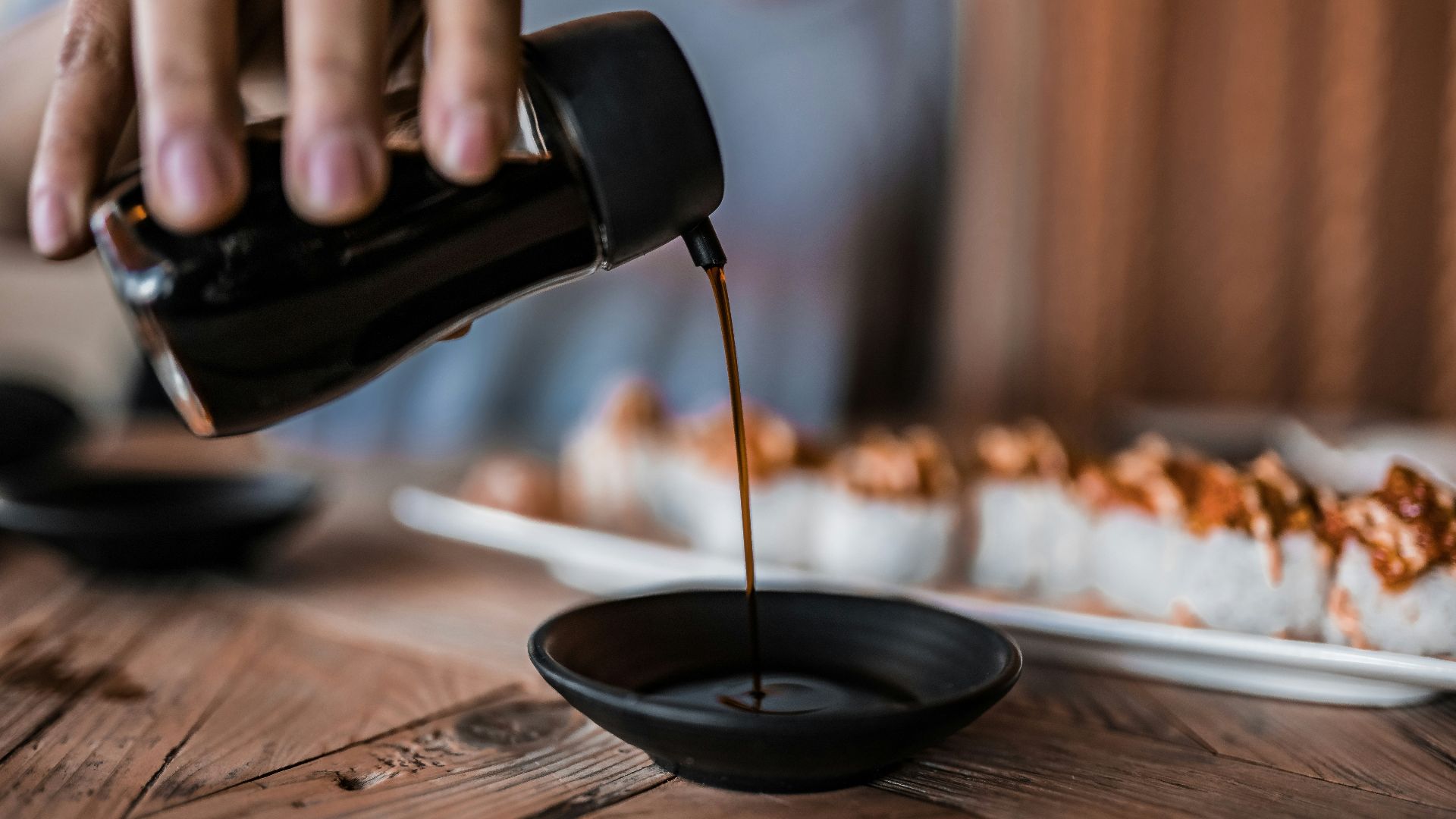 person pouring coffee on black ceramic mug