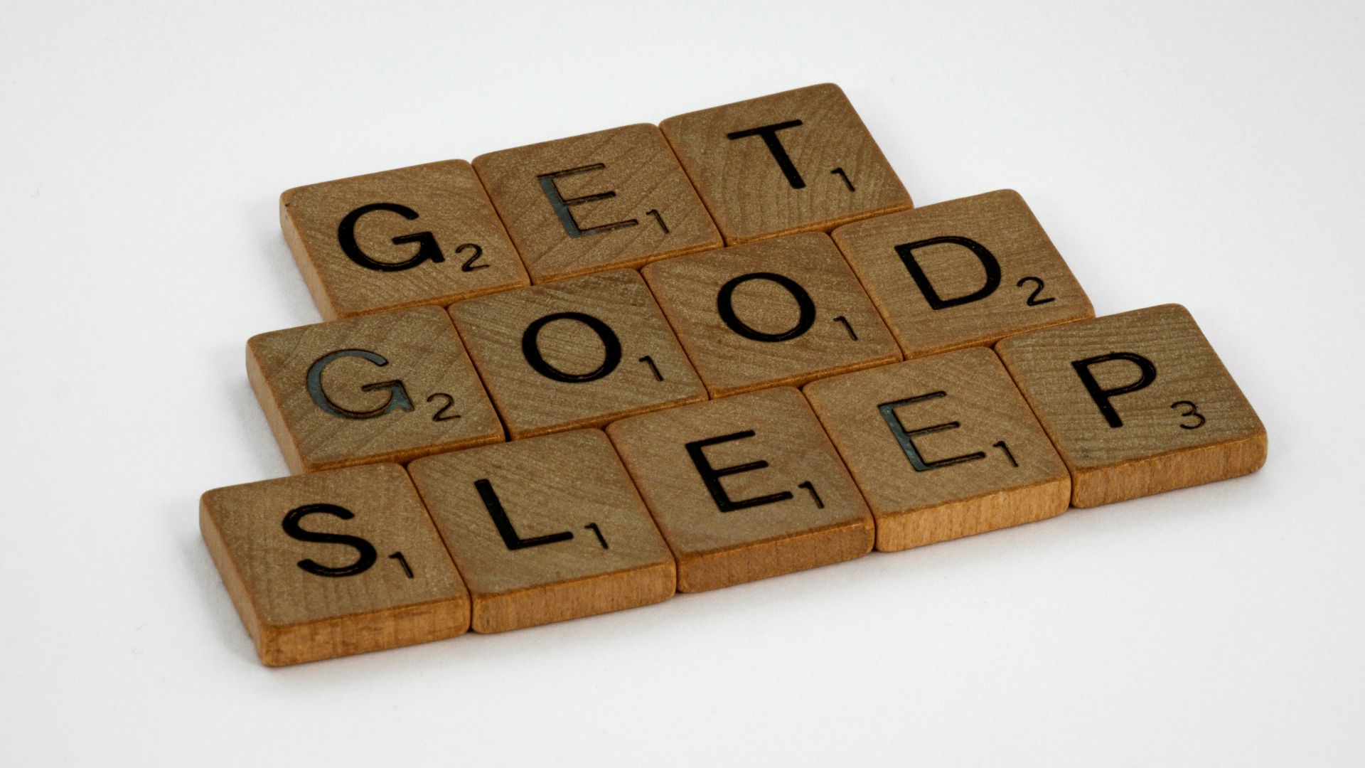 brown wooden letter blocks on white surface