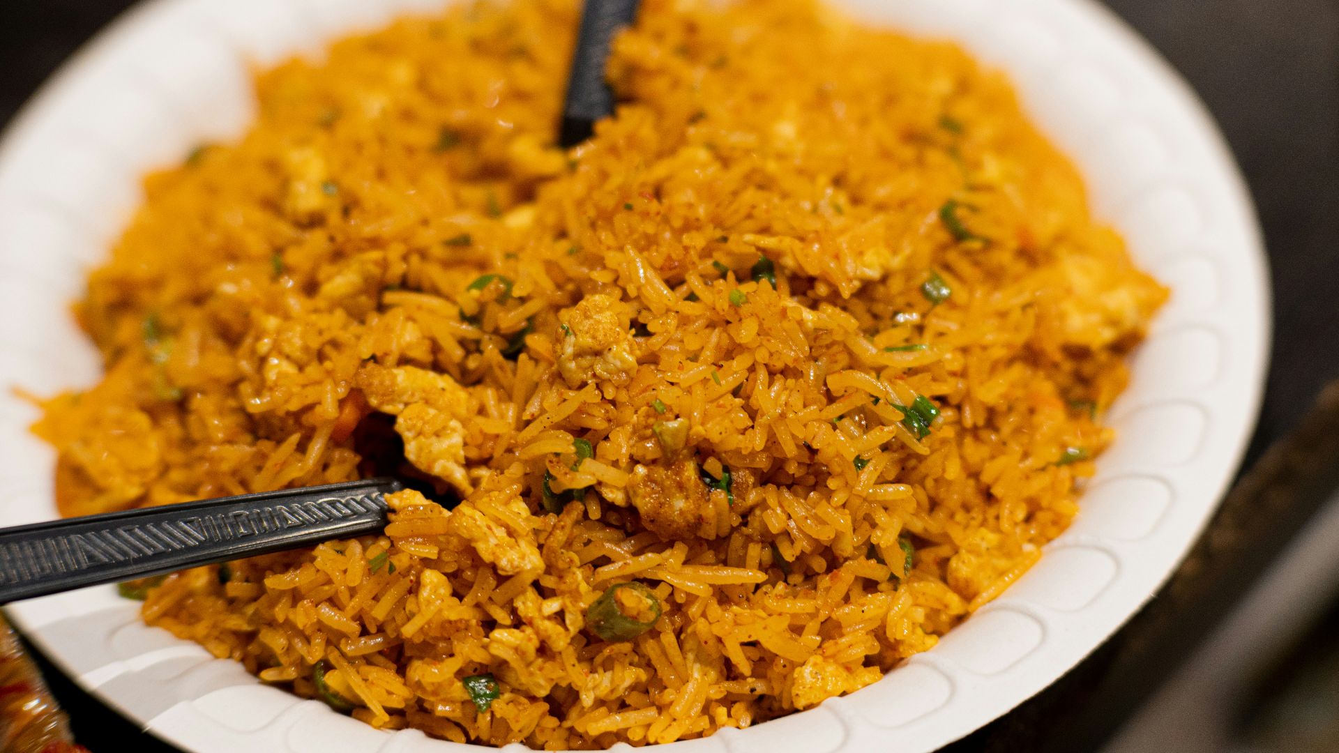 a white plate topped with rice and two black spoons
