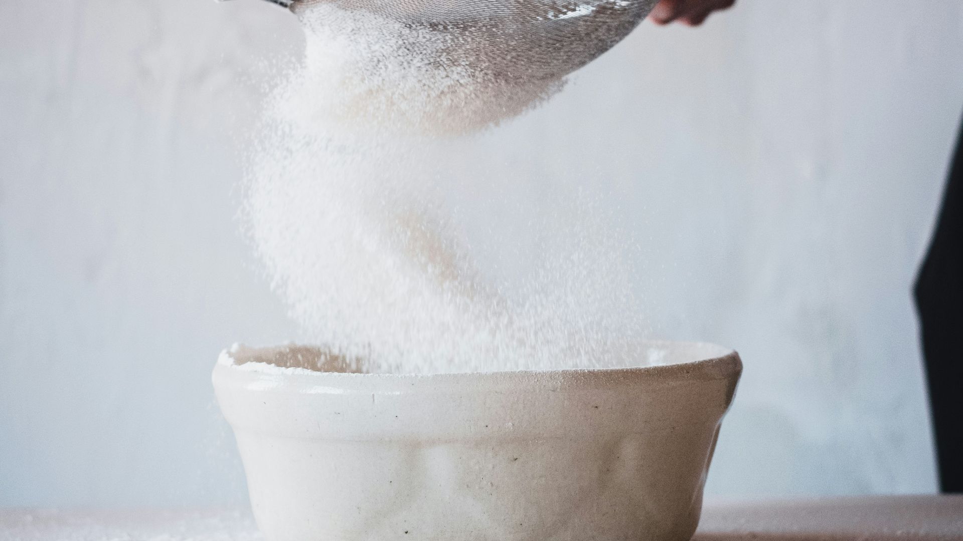 person pouring water on white ceramic bowl