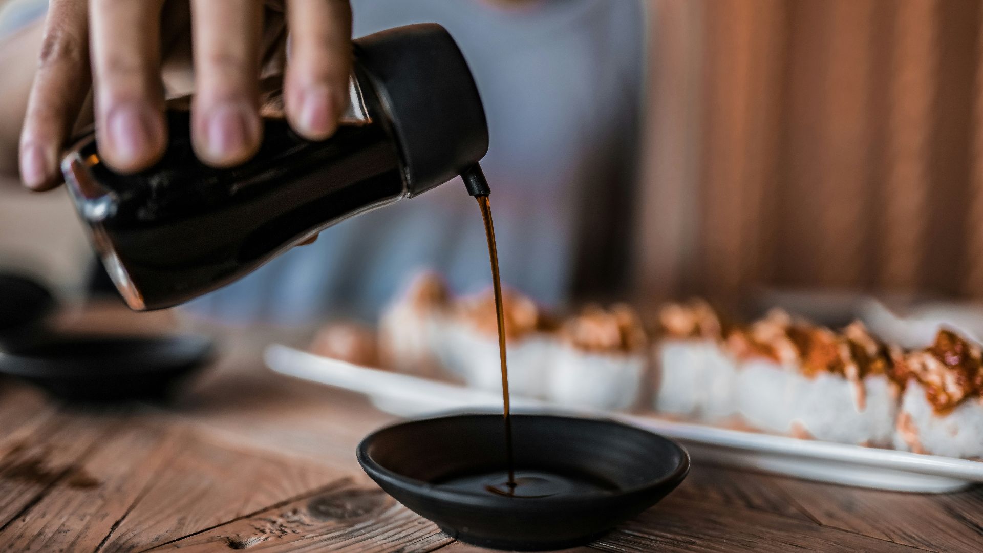 person pouring coffee on black ceramic mug