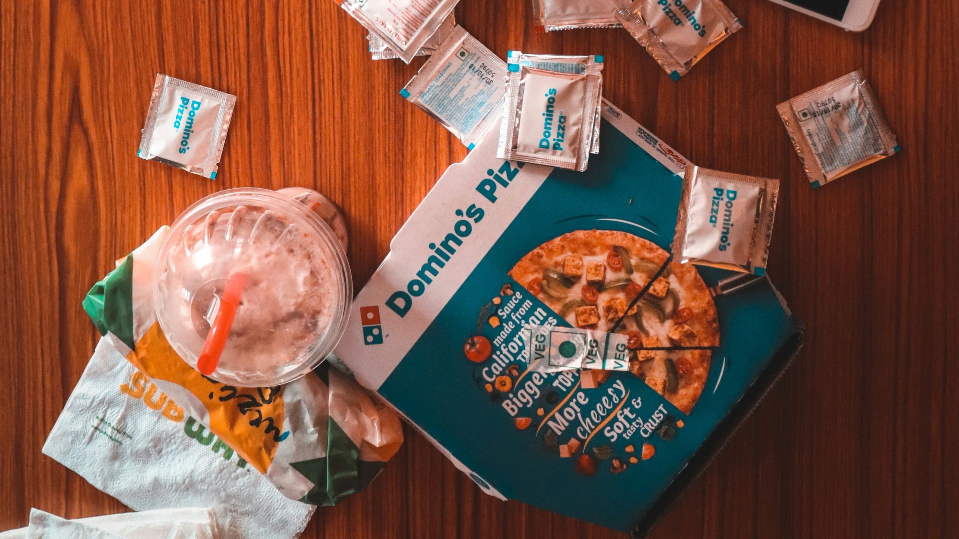 pizza and sauce packs beside iPhone on table