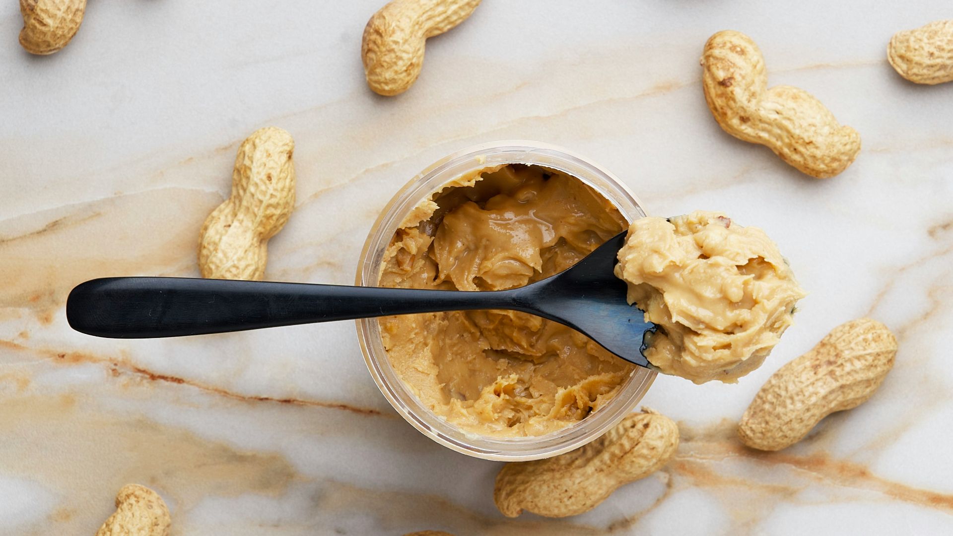peanut butter with black spoon