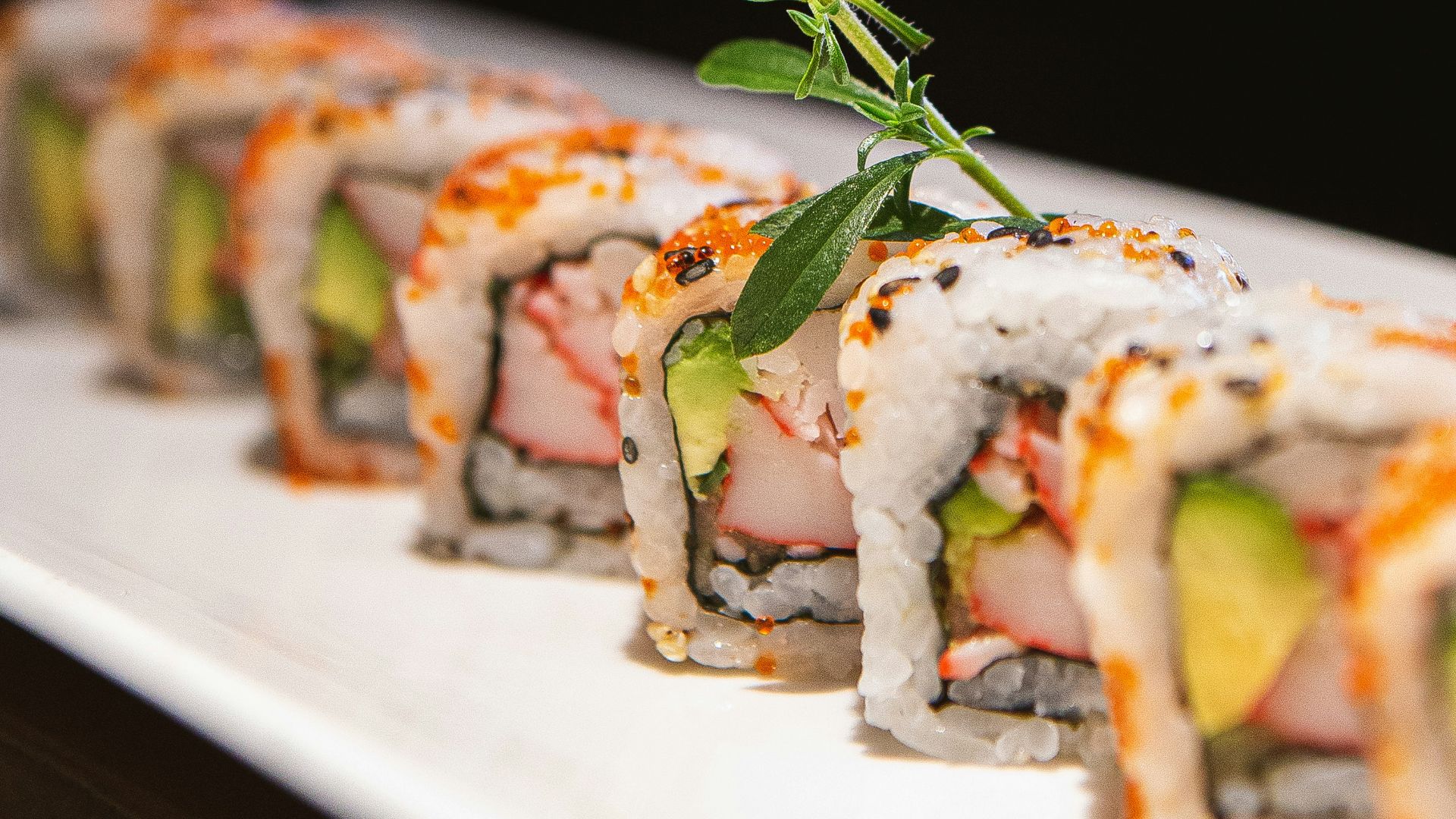 a white plate topped with sushi covered in sauce