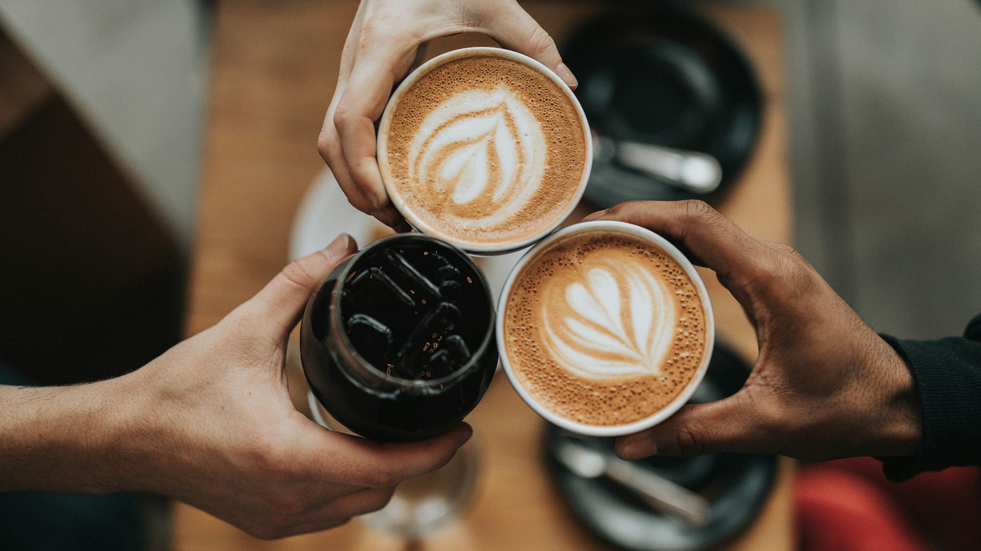 three person holding beverage cups